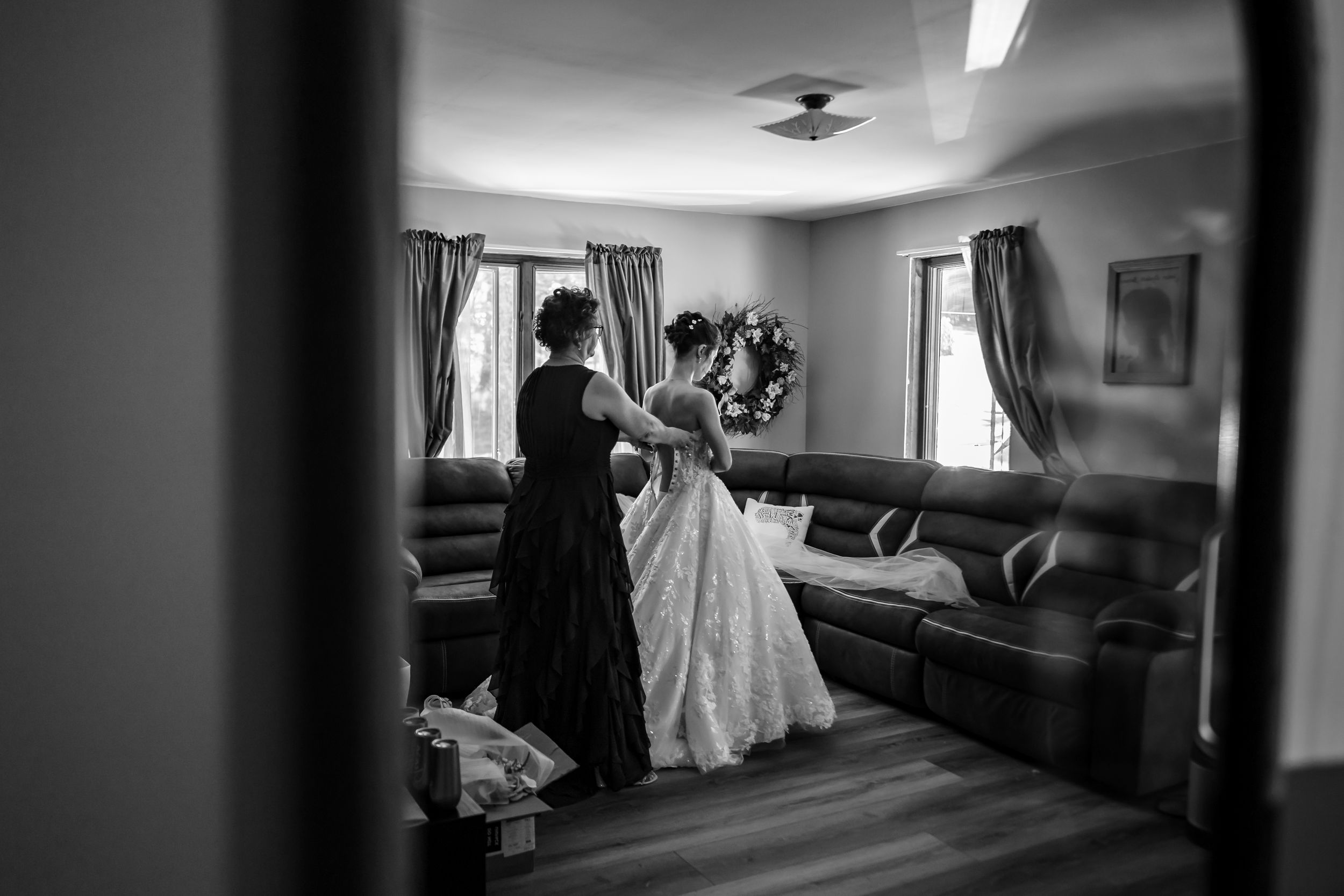 Black and white interior shot of an empty room with natural light streaming through windows.
