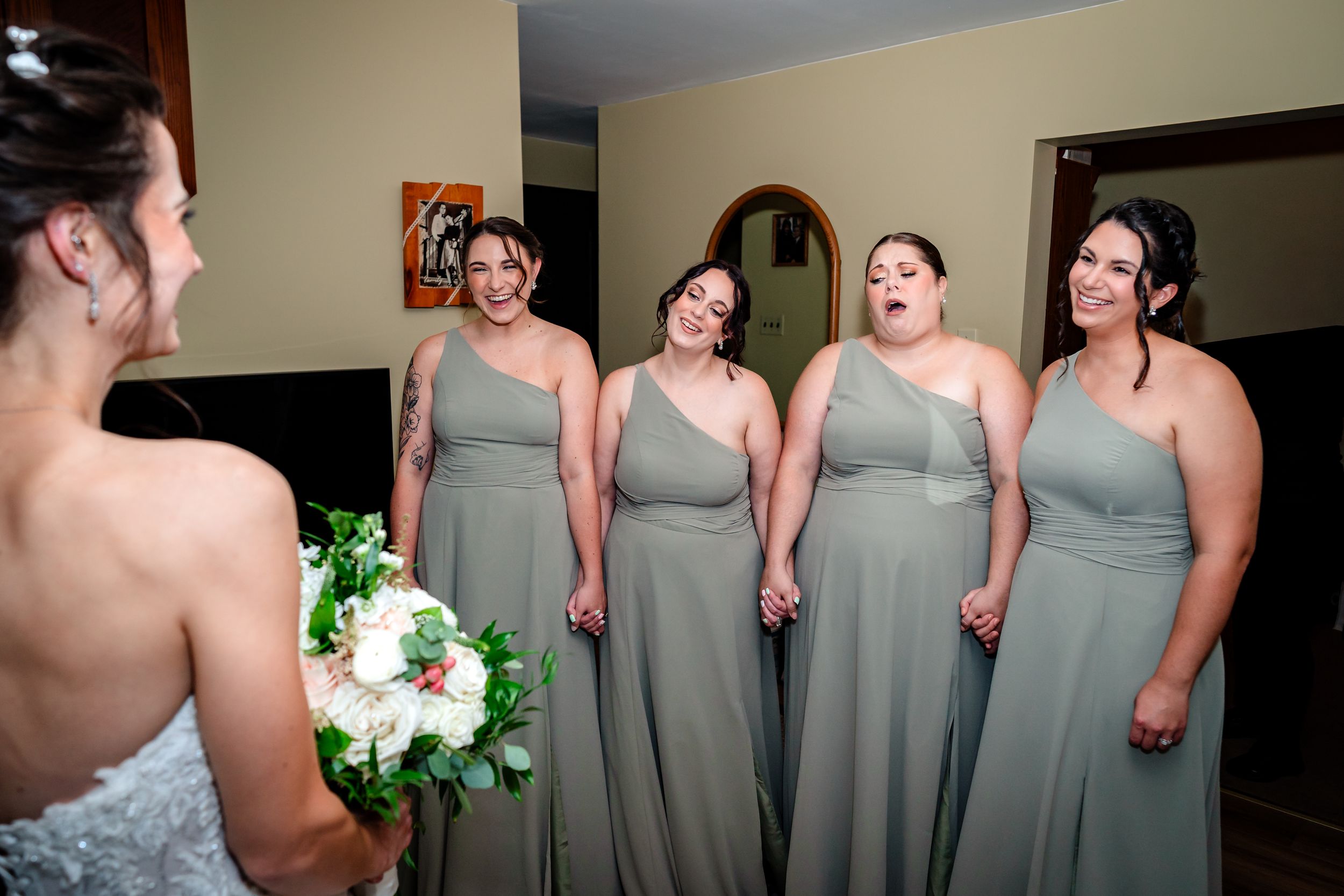 Bridesmaids in elegant gray dresses stand together during wedding preparations.