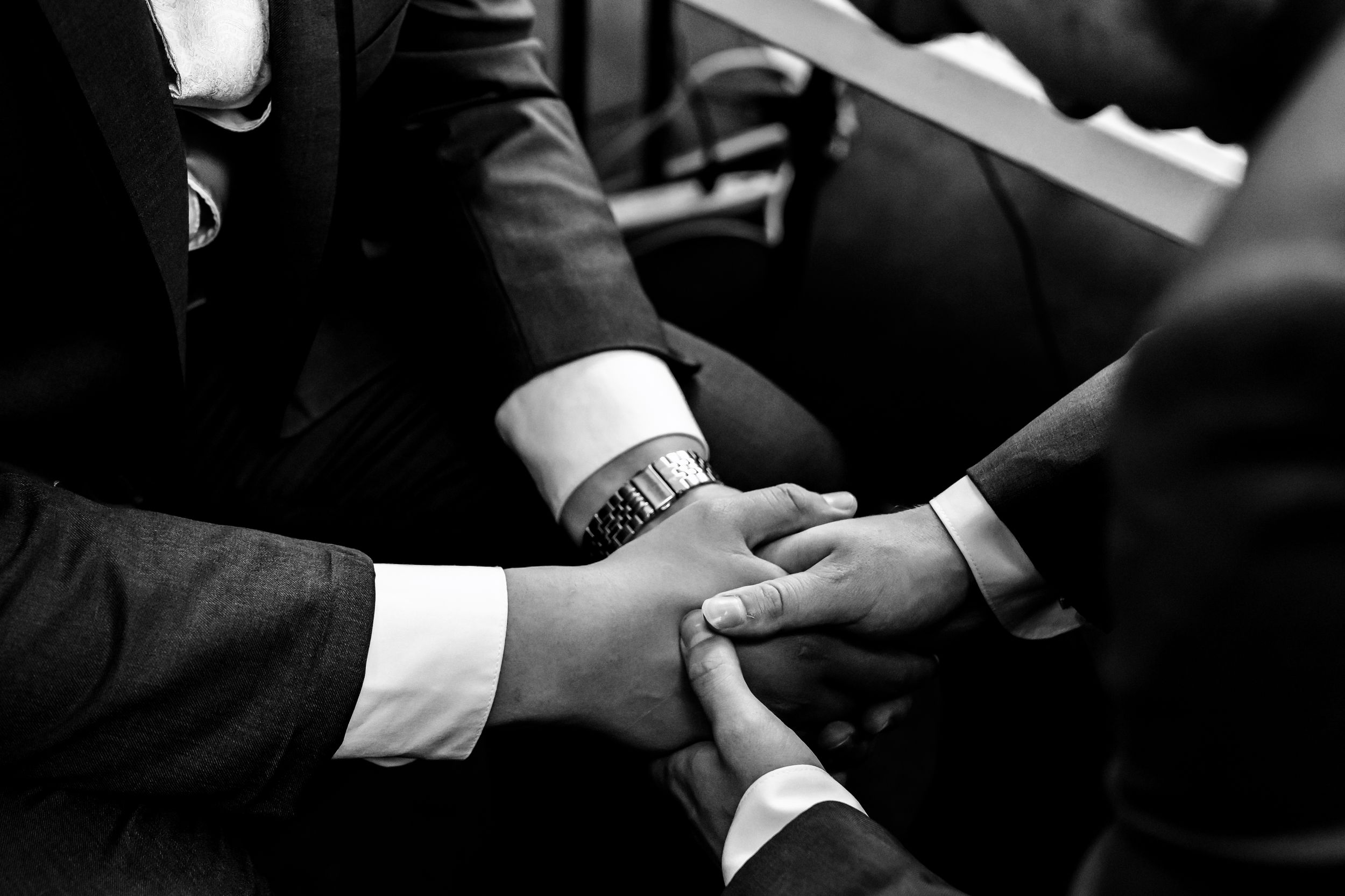 Close-up of formal attire and hands during an elegant wedding ceremony.