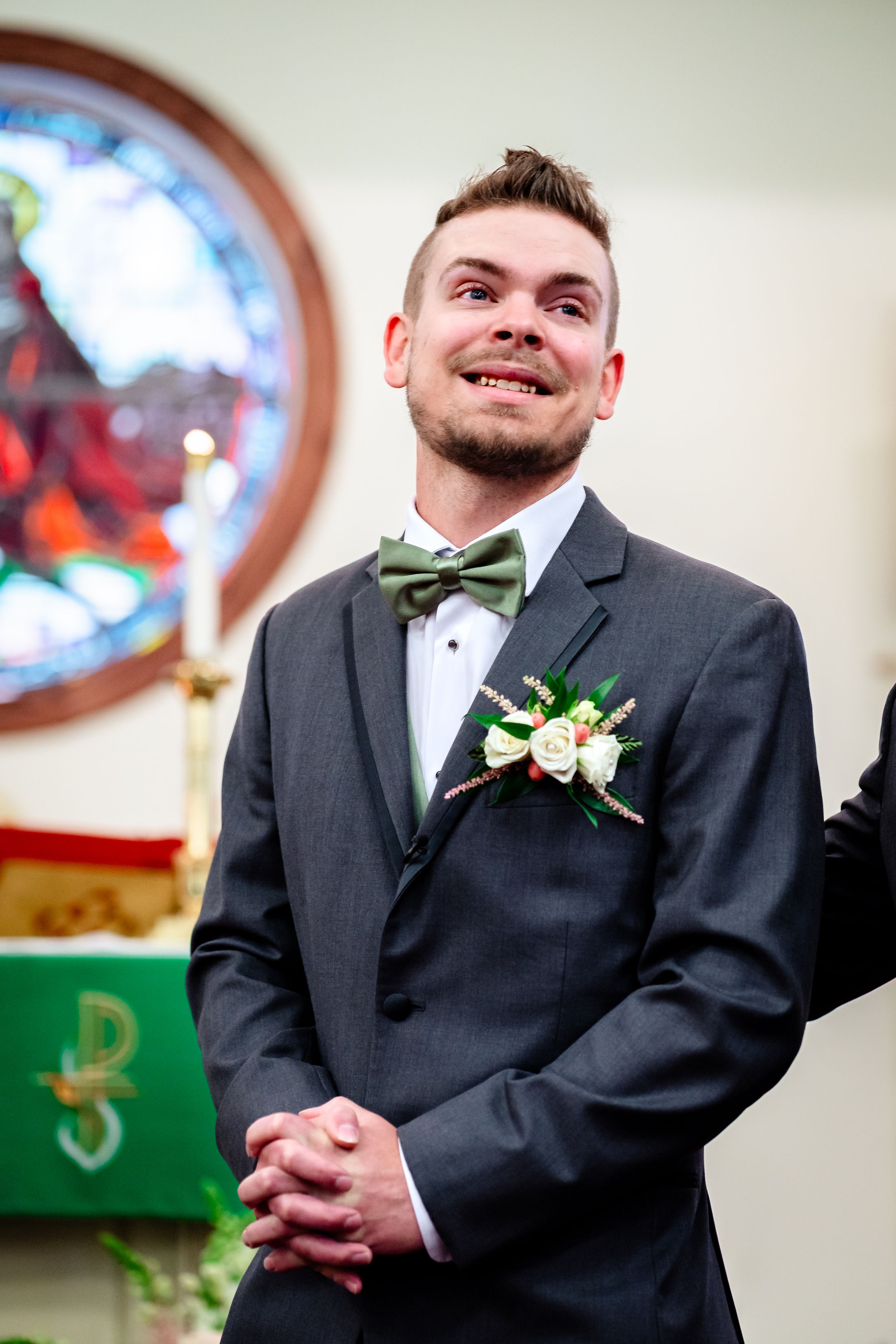 Wedding ceremony in a church with stained glass windows and traditional decor.
