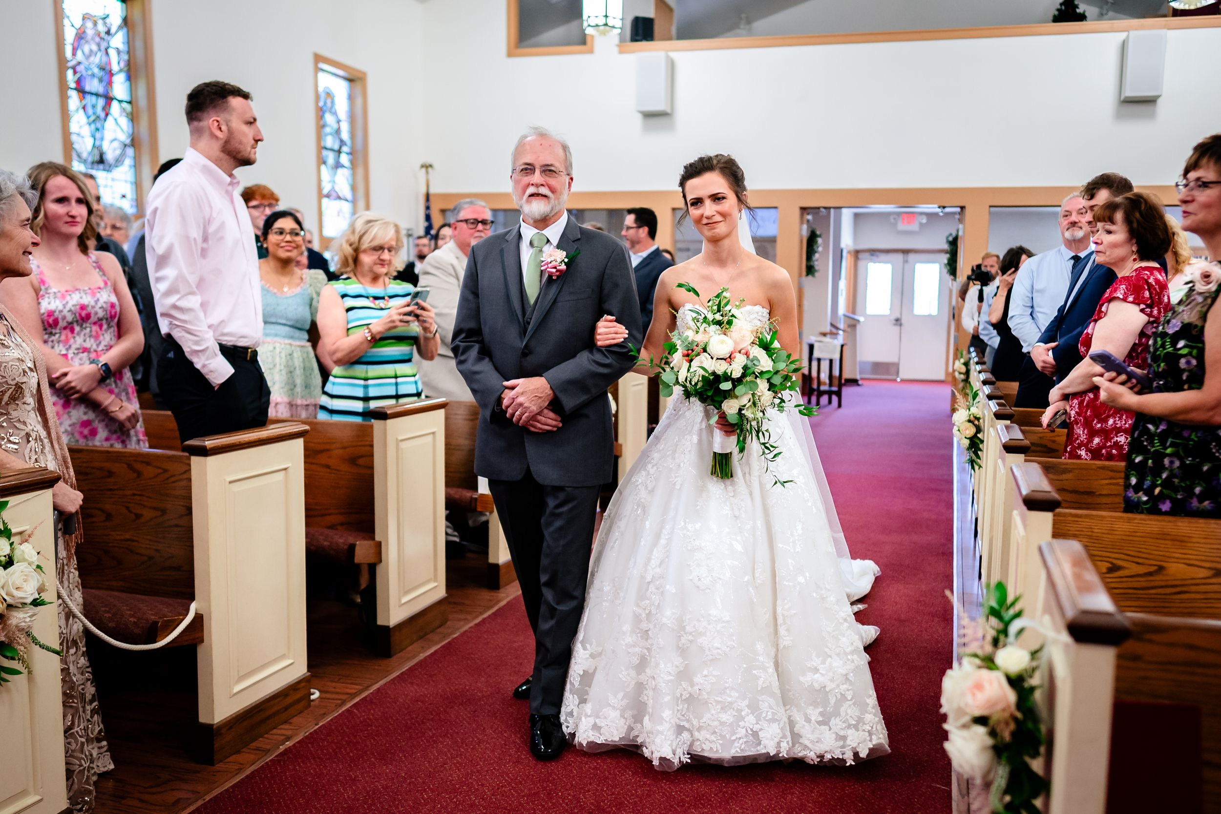 Traditional church wedding ceremony with guests filling the pews and elegant decorations.