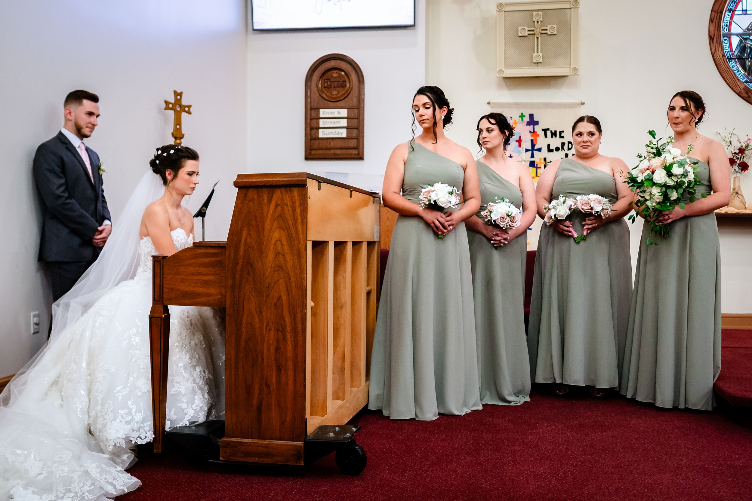 Church wedding ceremony with bridesmaids in sage green dresses and traditional decor.