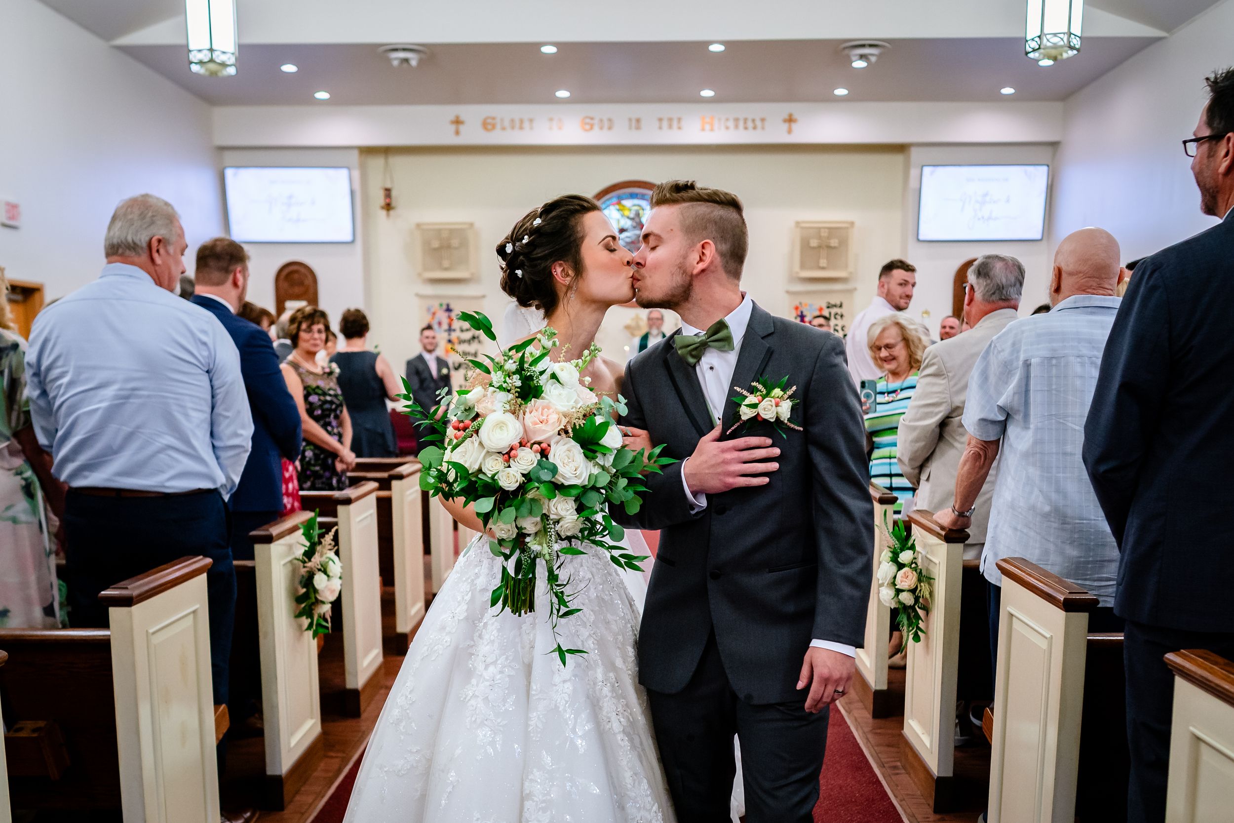 Wedding party and guests celebrate inside modern church sanctuary.