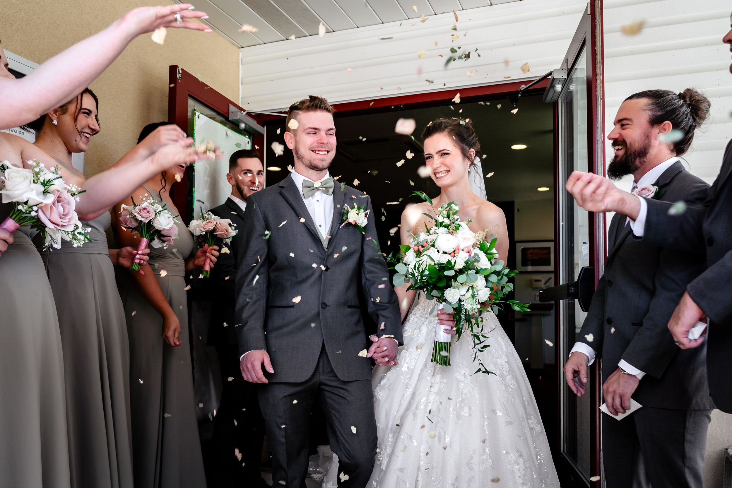 Wedding celebration with guests throwing confetti at the newlyweds.