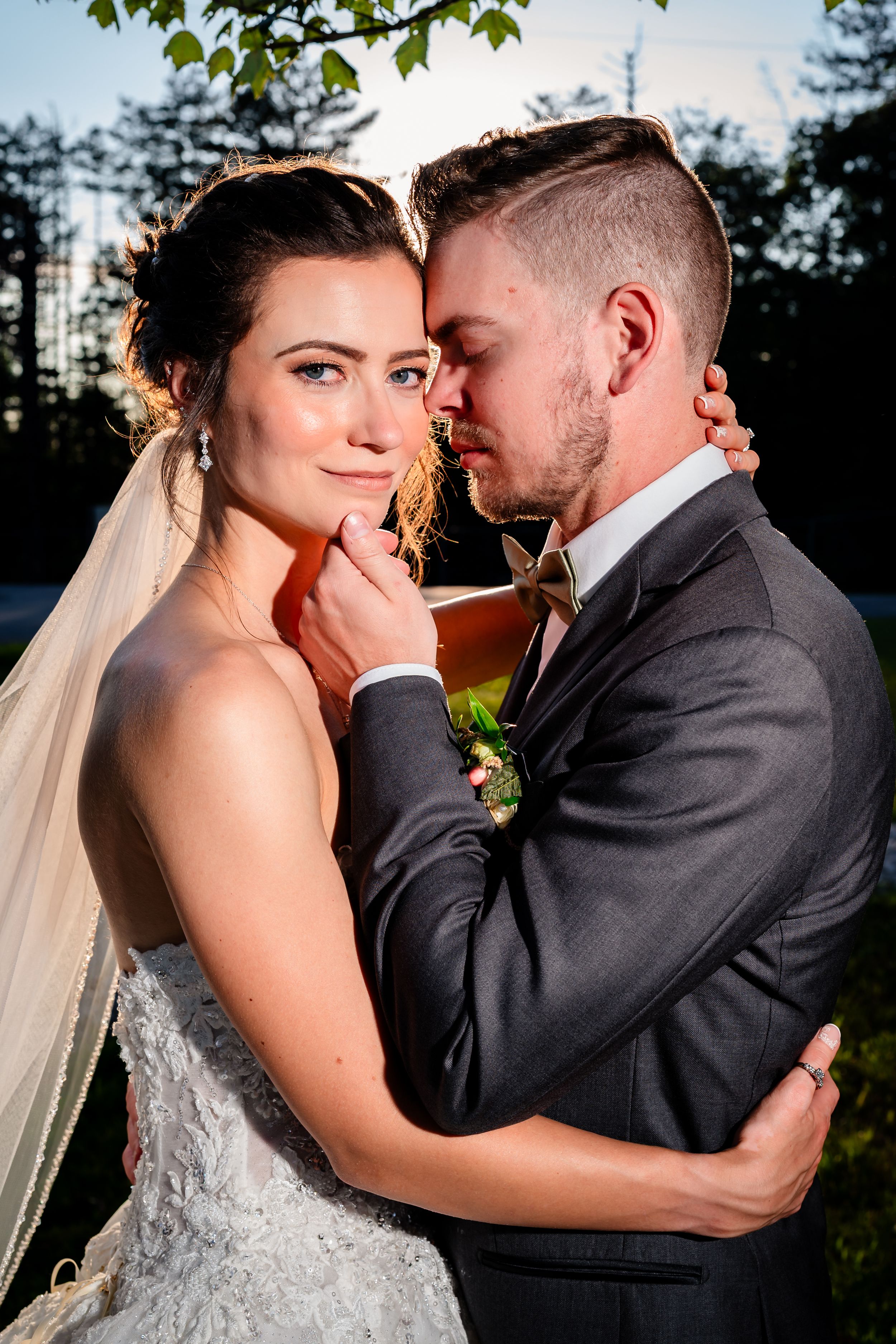 An intimate wedding portrait captured during golden hour outdoors.