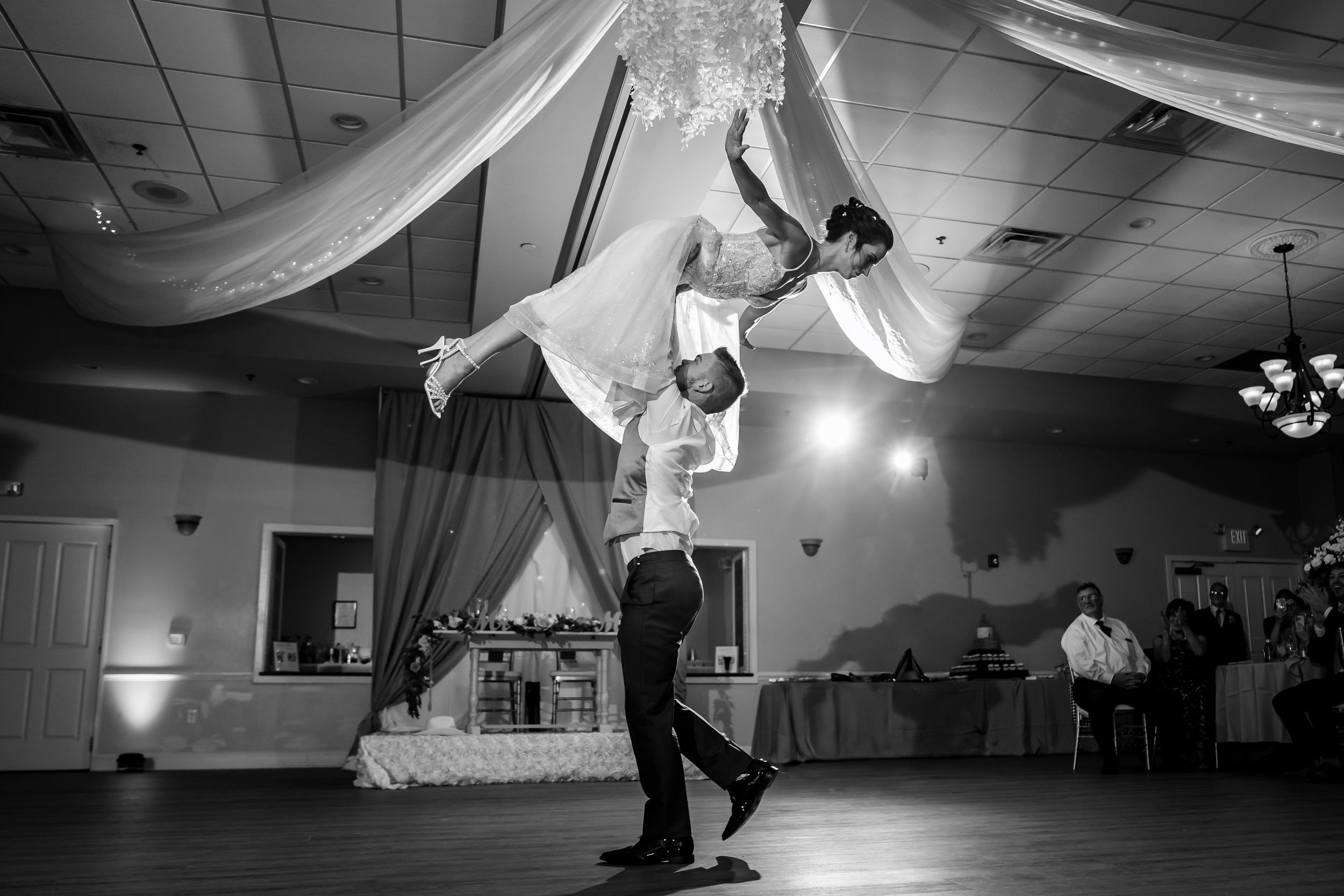 Black and white photo of spectacular wedding dance lift in reception hall.