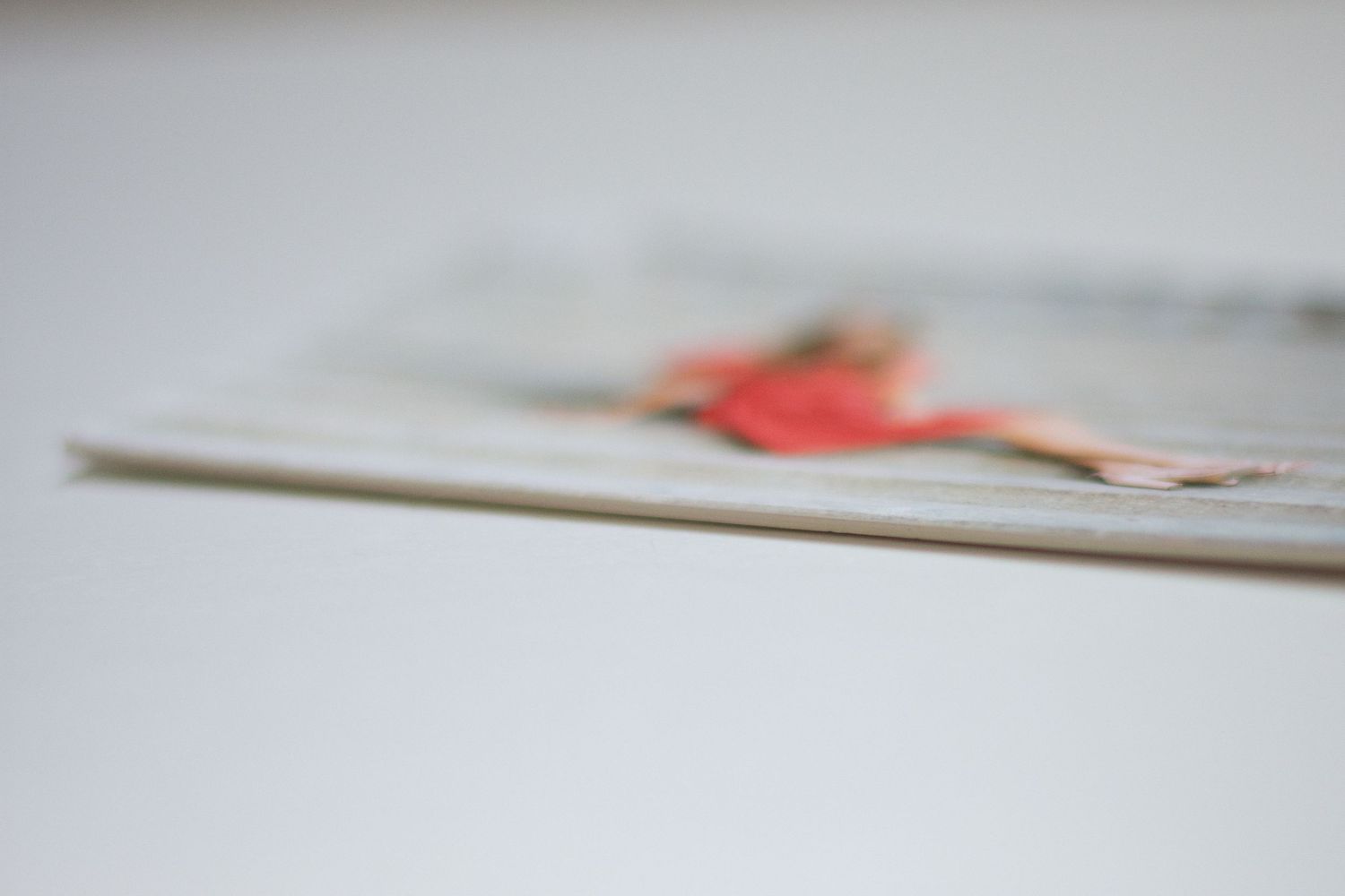 Soft focus view of printed photographs arranged on a light gray surface.