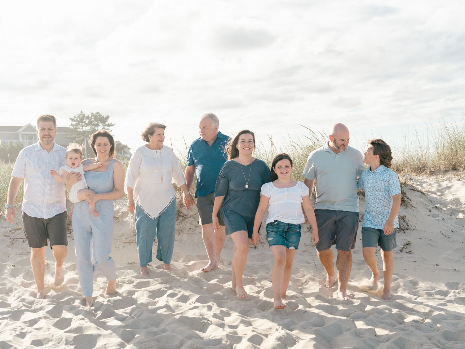 Parents and children walking hand in hand along Spring Lake beach NJ.