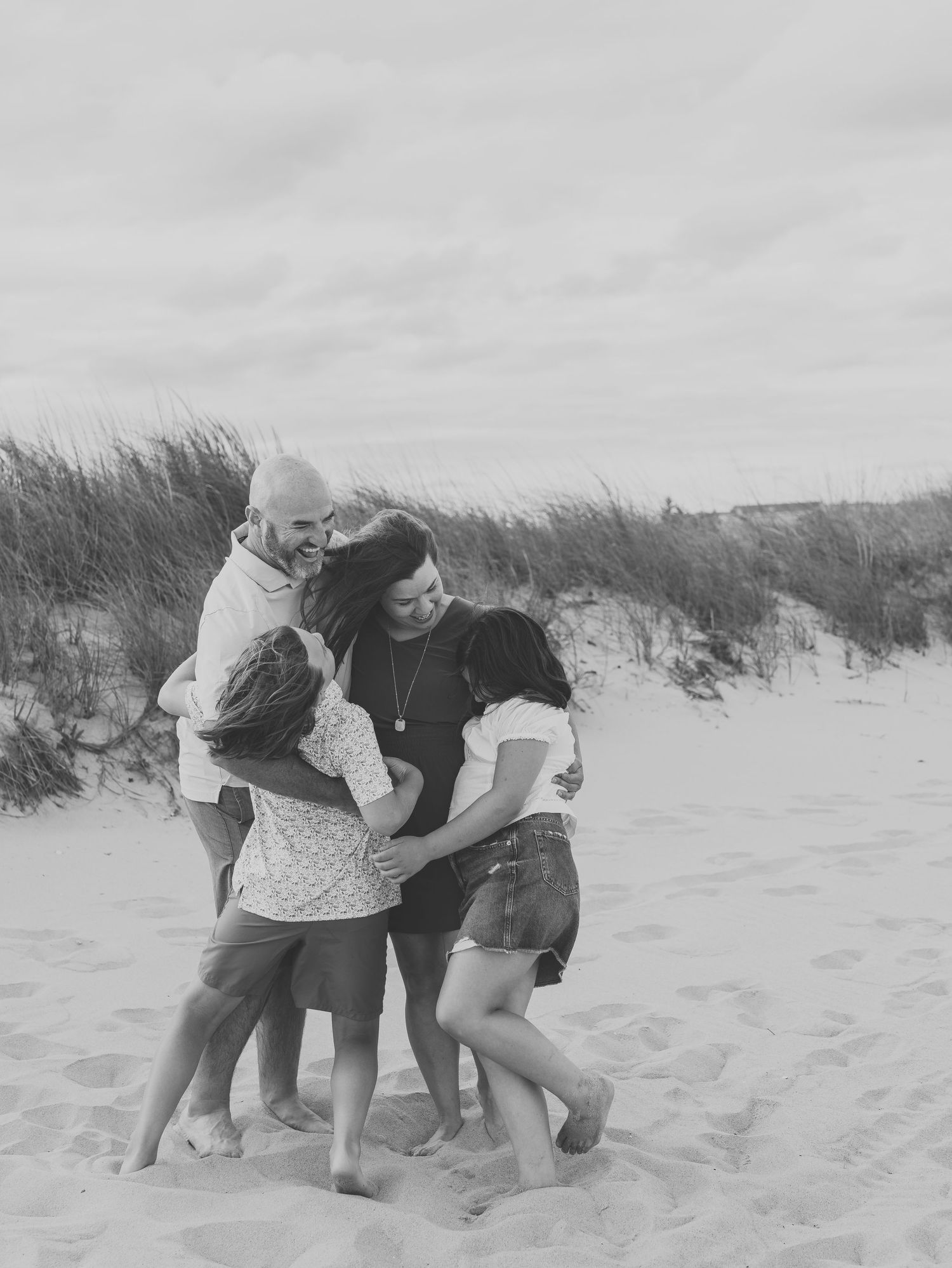 Family running and playing in the sand during Spring Lake NJ family photo session.