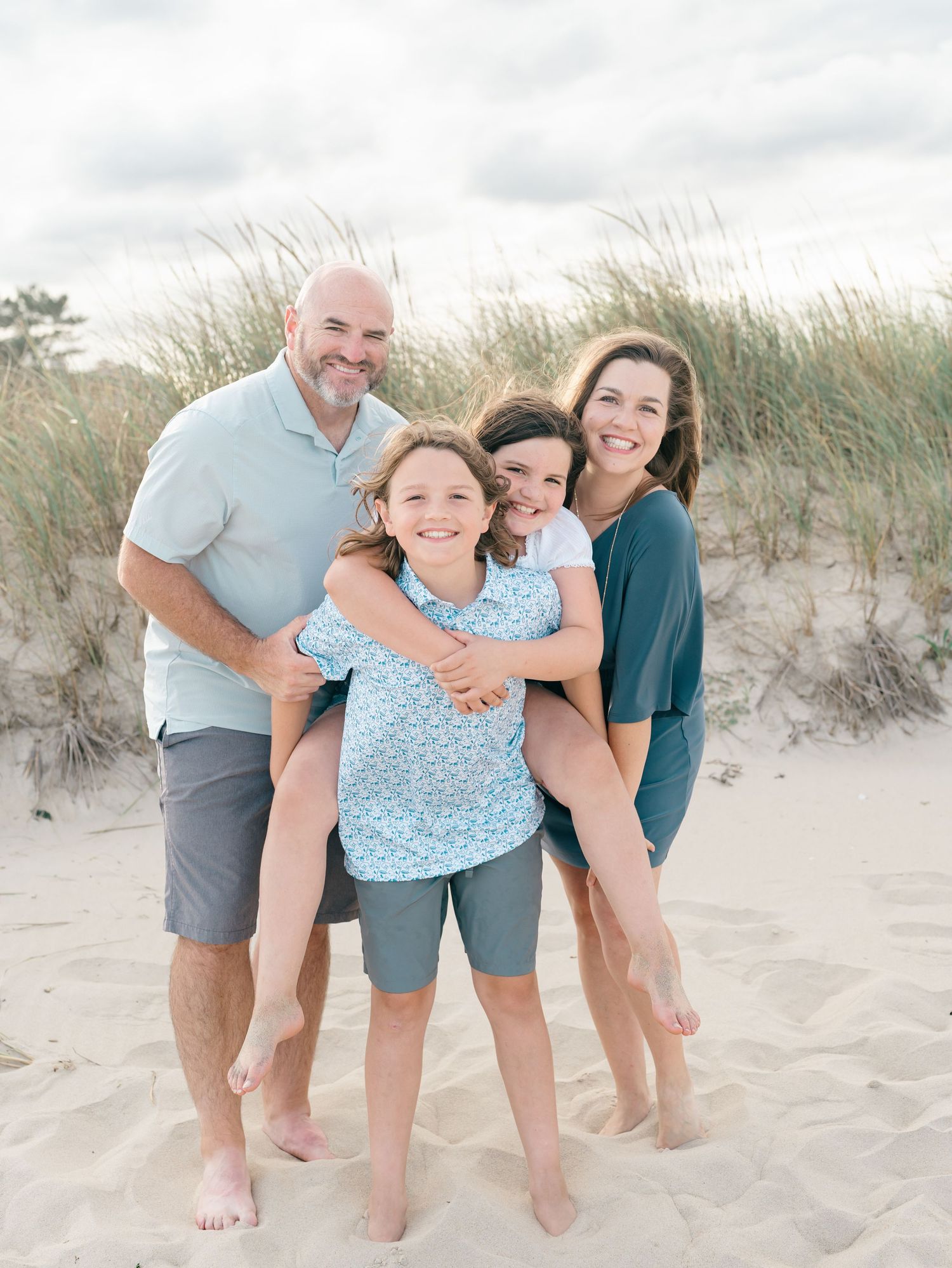 Natural candid photo of siblings on the shoreline in Spring Lake NJ with their parents.