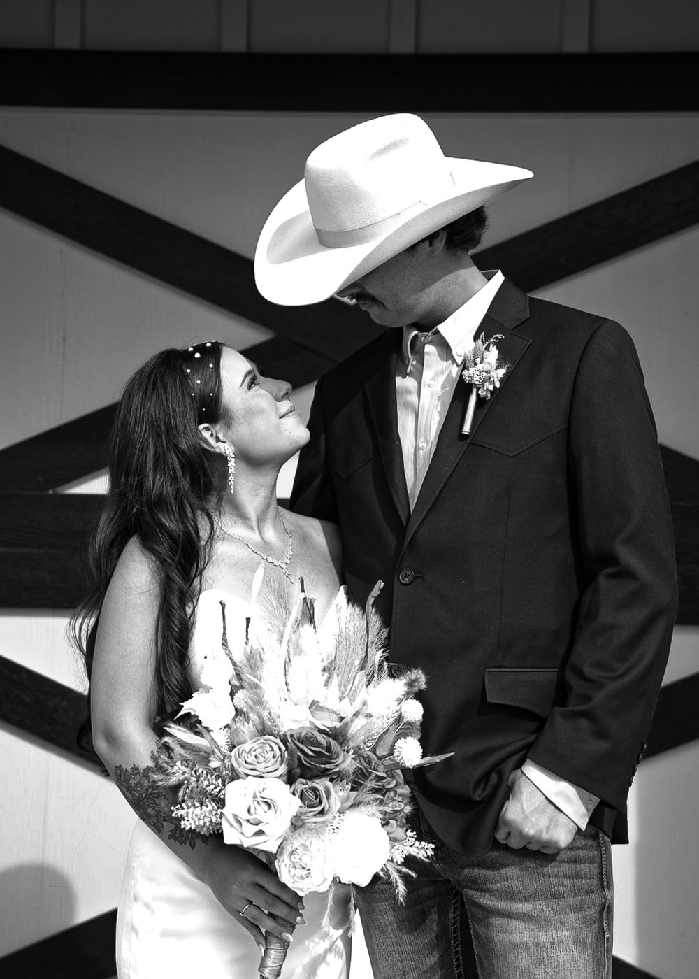 Black and white wedding portrait with geometric barn door backdrop.