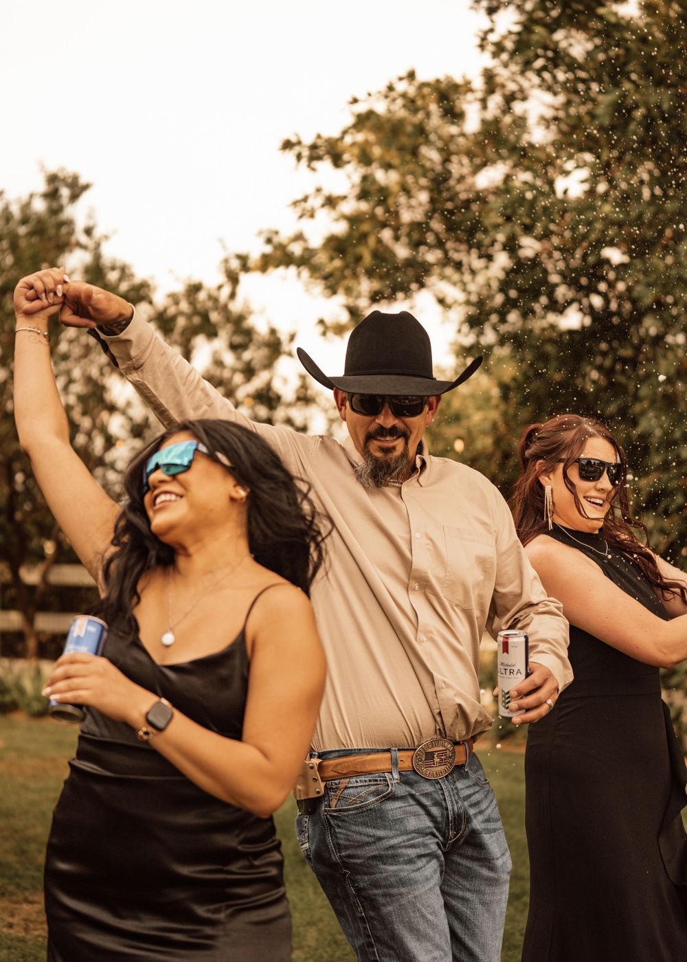Wedding guests dancing and celebrating at an outdoor reception.