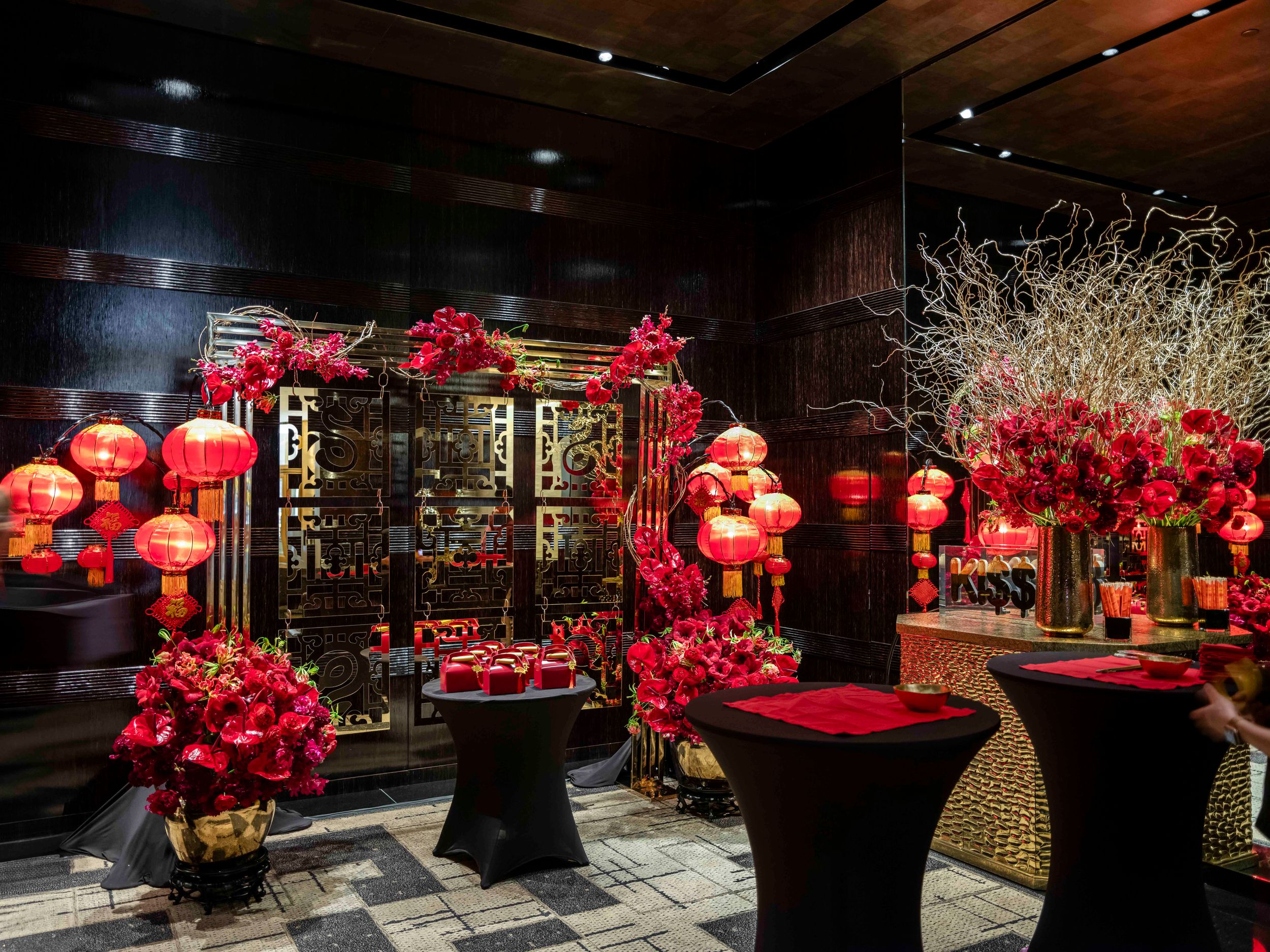 Traditional Chinese New Year celebration setup with red lanterns and floral decorations in an elegant dark room.
