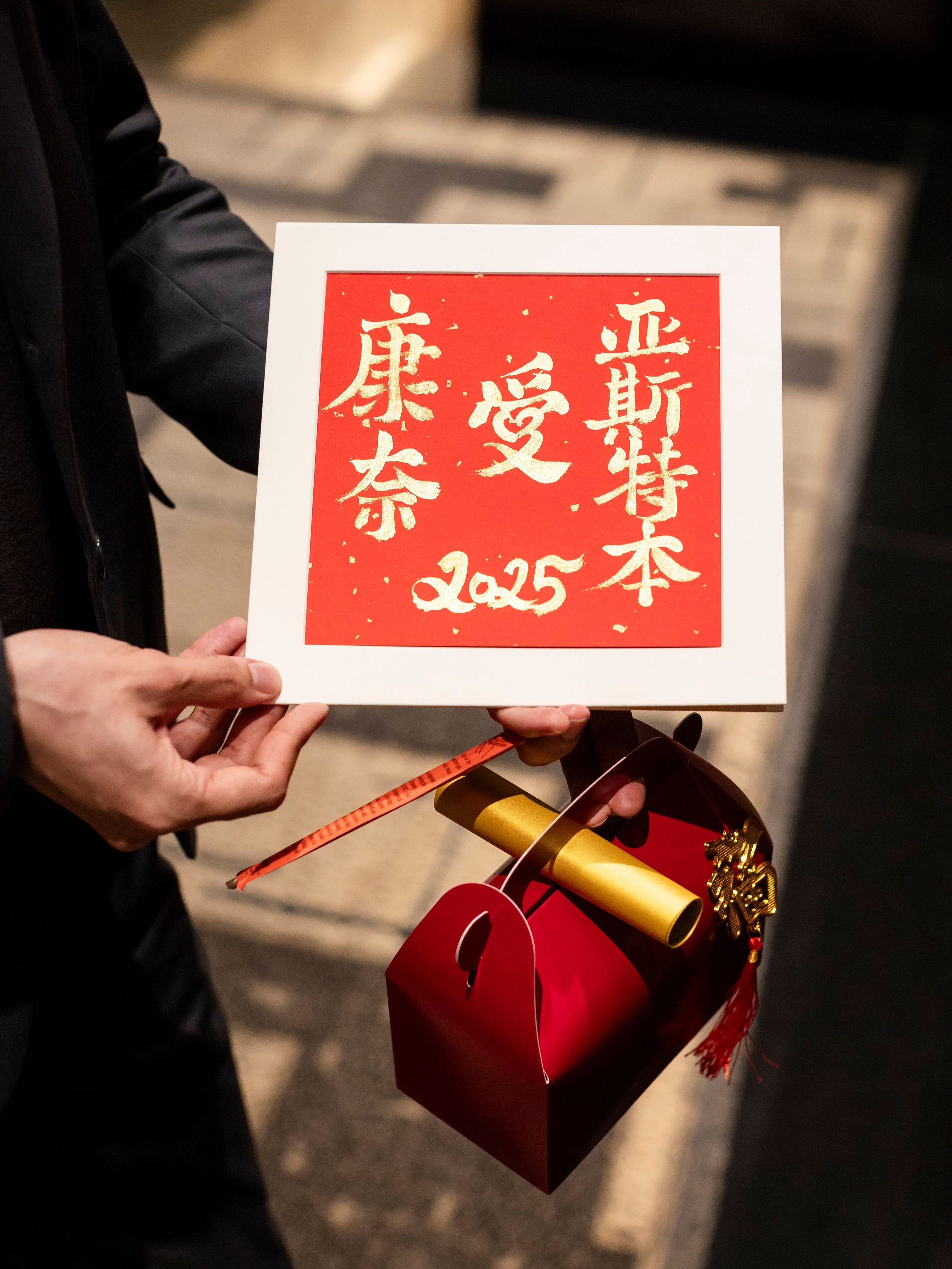 Chinese calligraphy sign in red with decorative gift box for 2025 celebration.