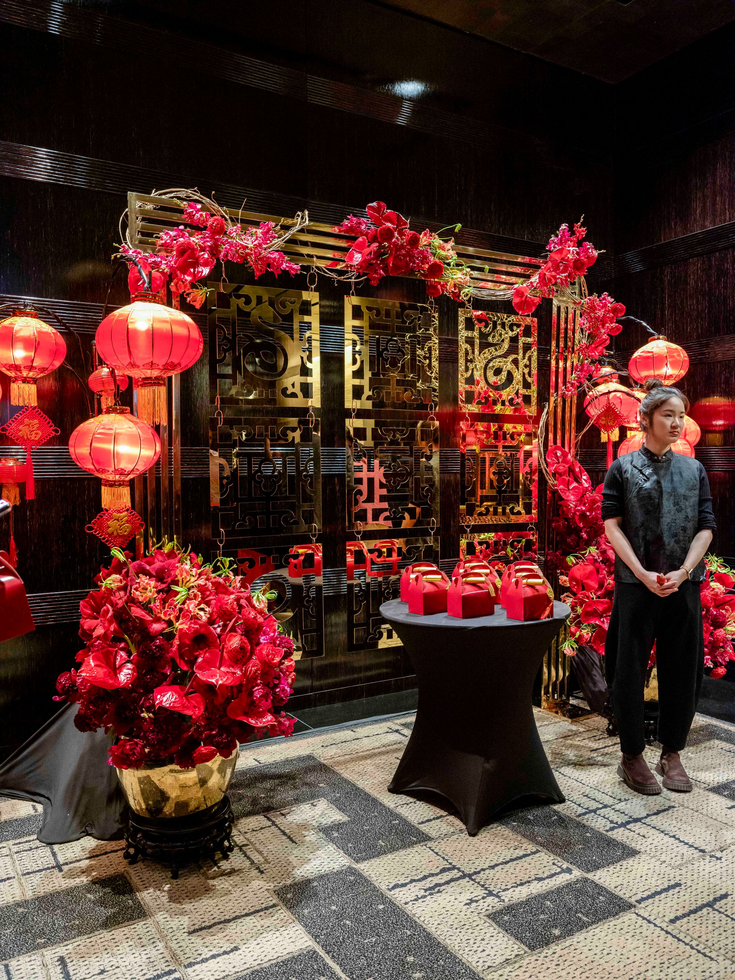 Elegant Chinese New Year display with ornate screen, red lanterns, and floral arrangements.