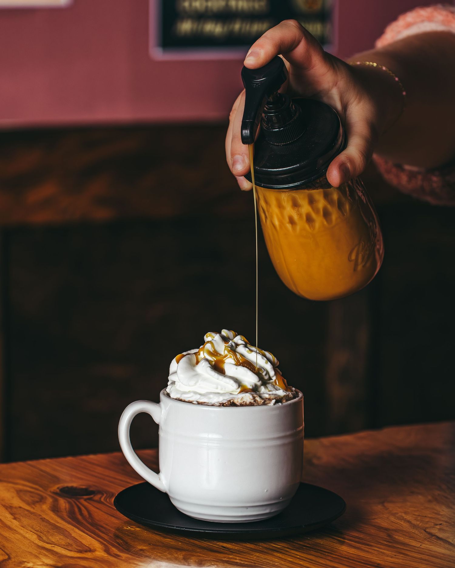 A series of photos showing honey being drizzled over a white bowl of whipped cream and walnuts served on a wooden table.