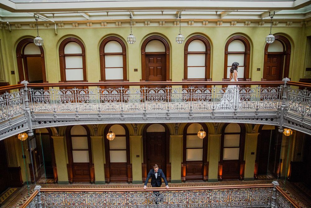 Historic building interior with ornate balcony and arched windows.