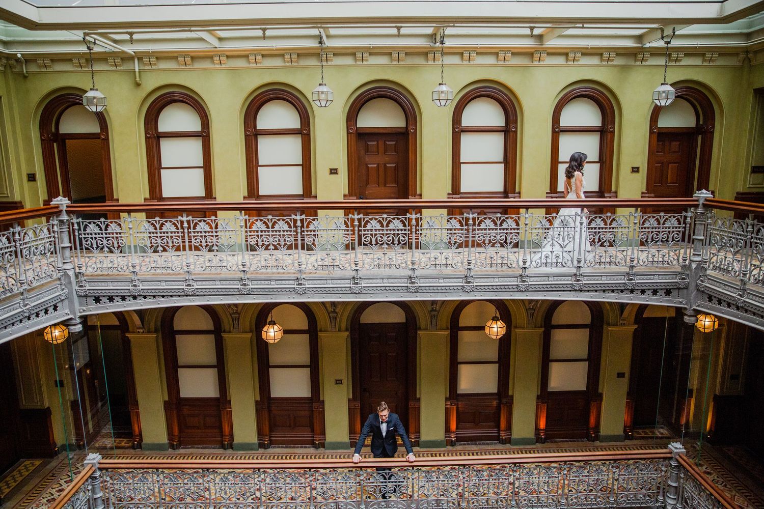 Historic building interior with ornate balcony and arched windows.
