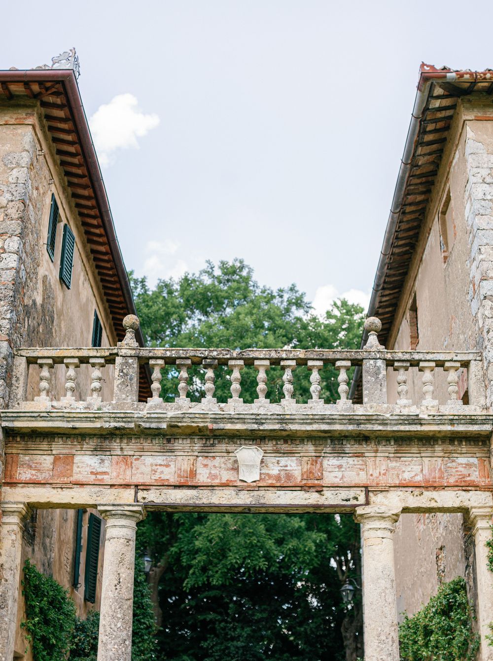 Classical Italian villa Borgo Stomennano colonnade with decorative stone balustrade and architectural details in natural garden setting.