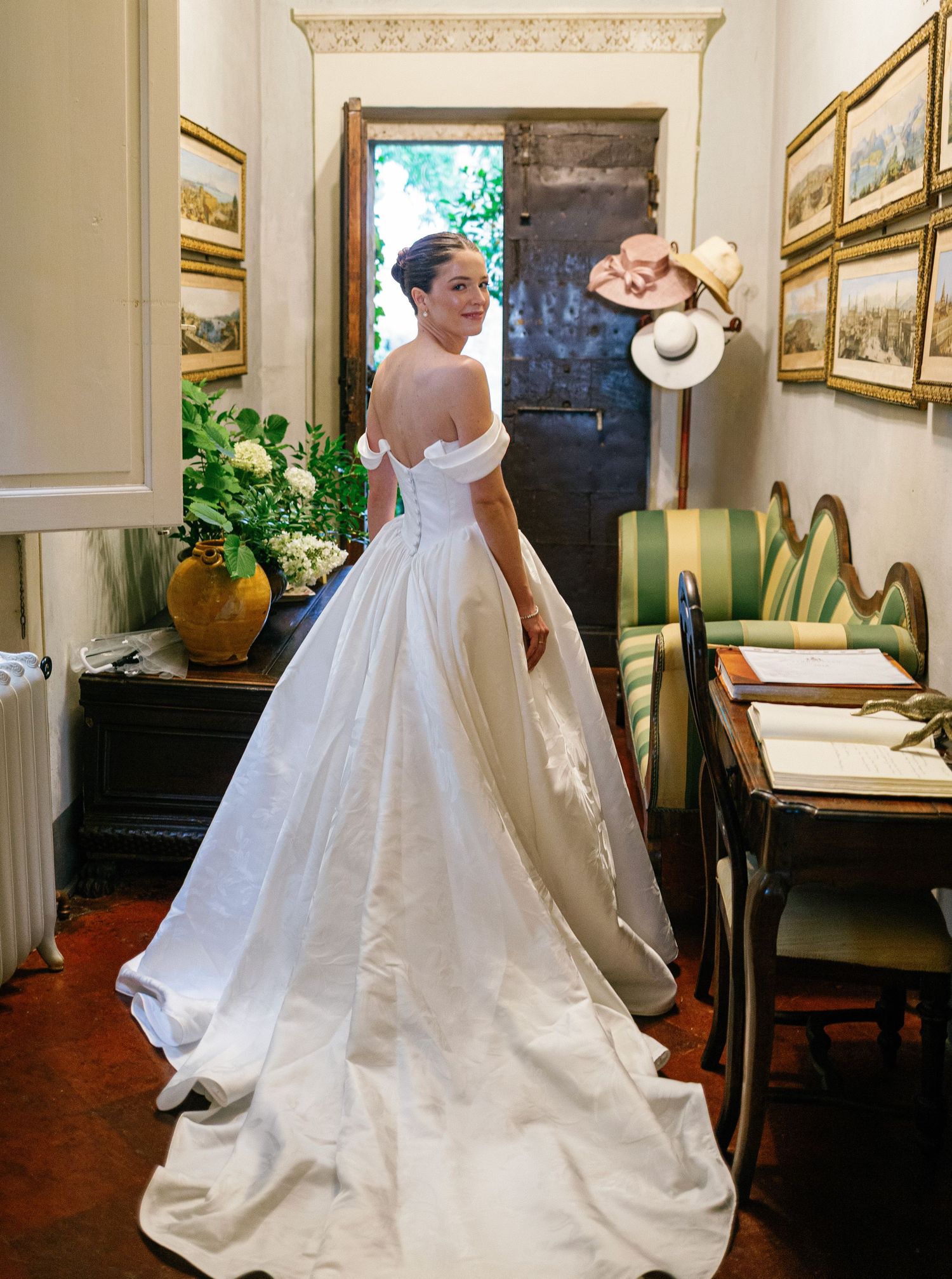 Elegant white wedding dress with flowing train shown in mirrored sequence of movements in indoor venue setting.