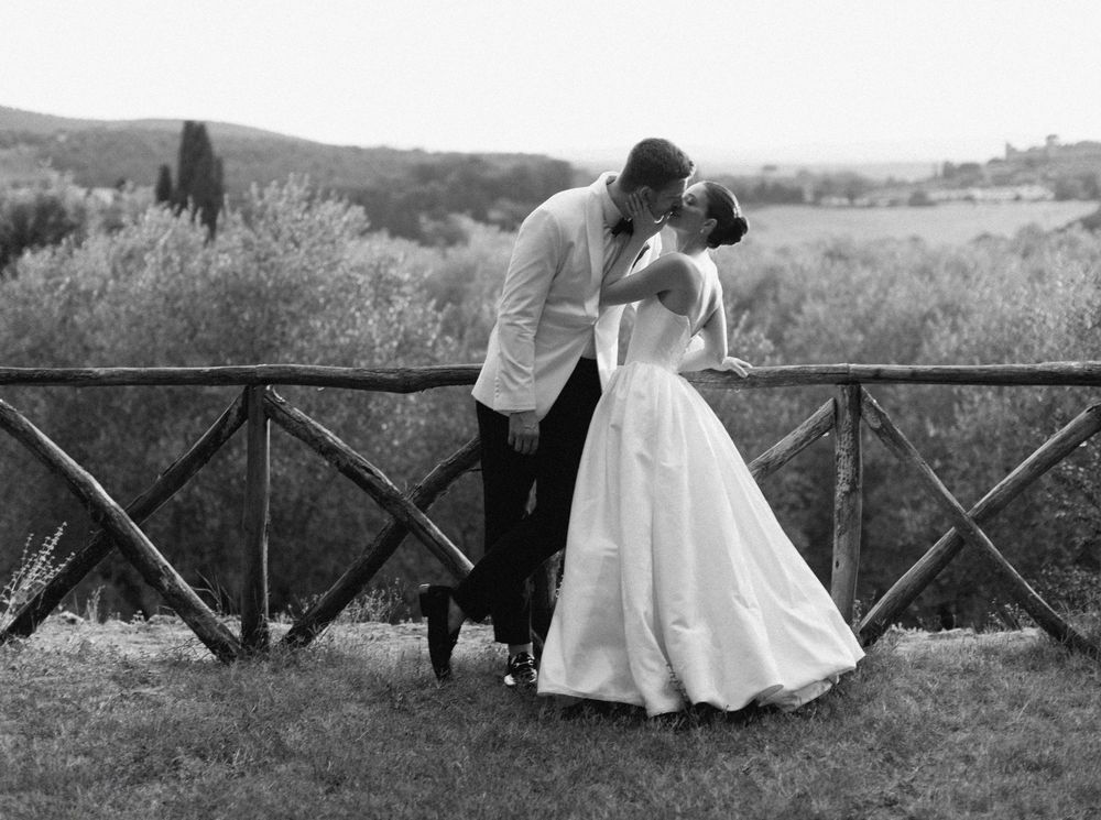 A dynamic sequence of black and white photographs shows a couple walking and embracing along a rustic wooden bridge at Borgo Stomennano.