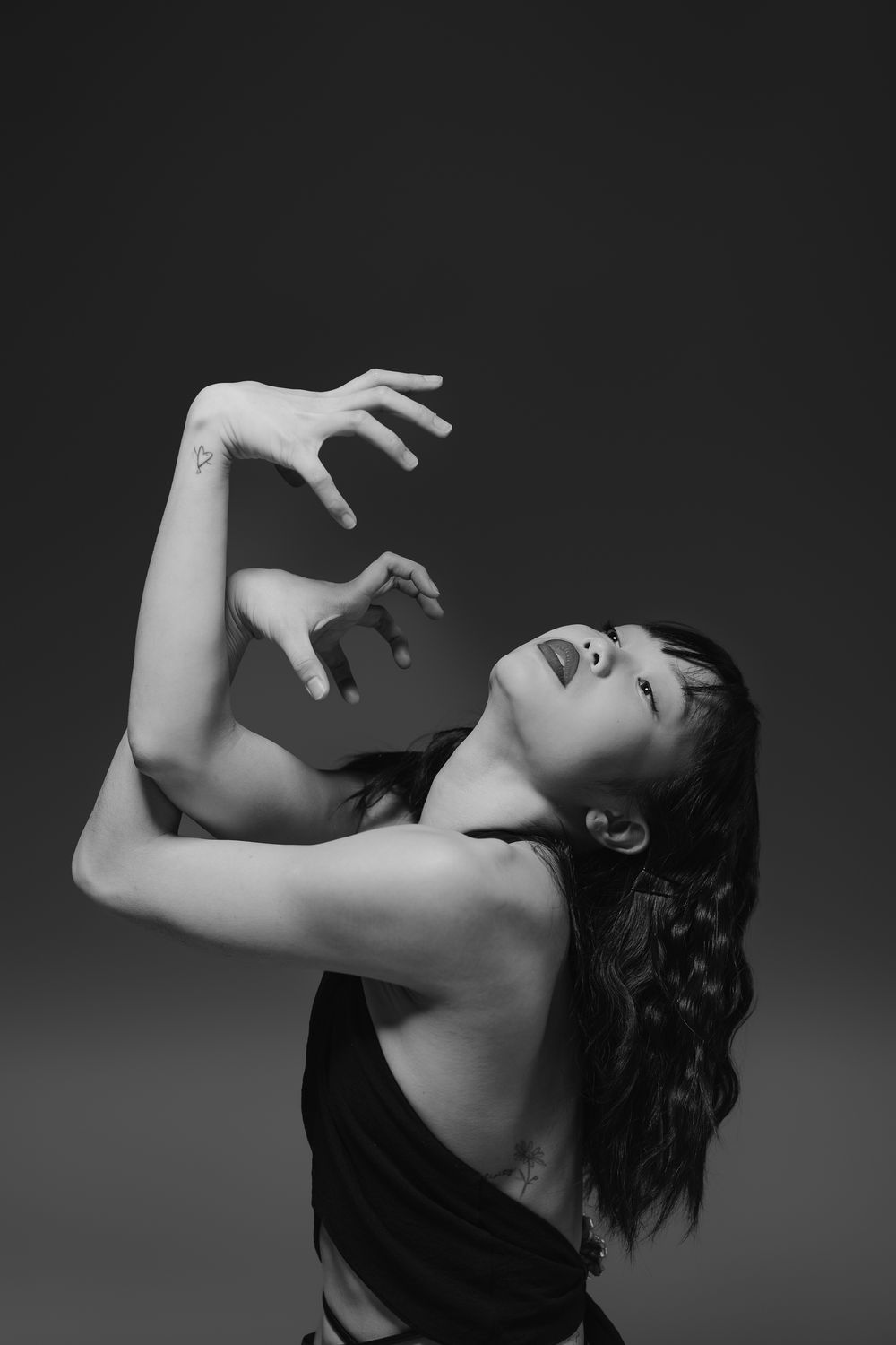 A dramatic black and white series showing an expressive dance performance with elegant arm movements and flowing hair.