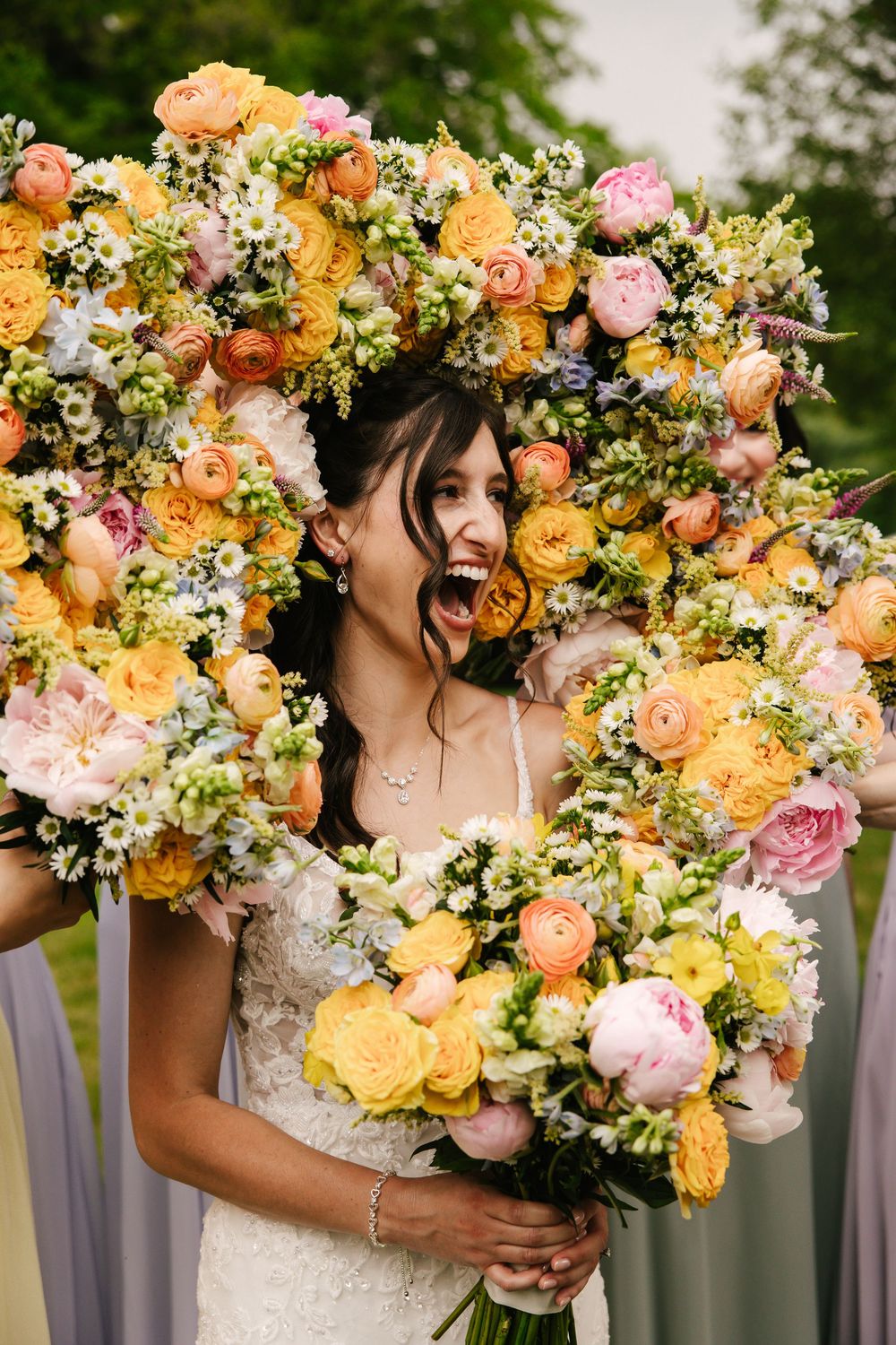 Vibrant peach and pink wedding bouquet with roses and mixed flowers.