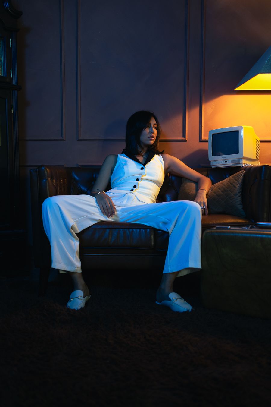 Editorial portrait of woman in Zara-style white suit, cinematic Miami motel room glow, high fashion photography by Mannyportraits.