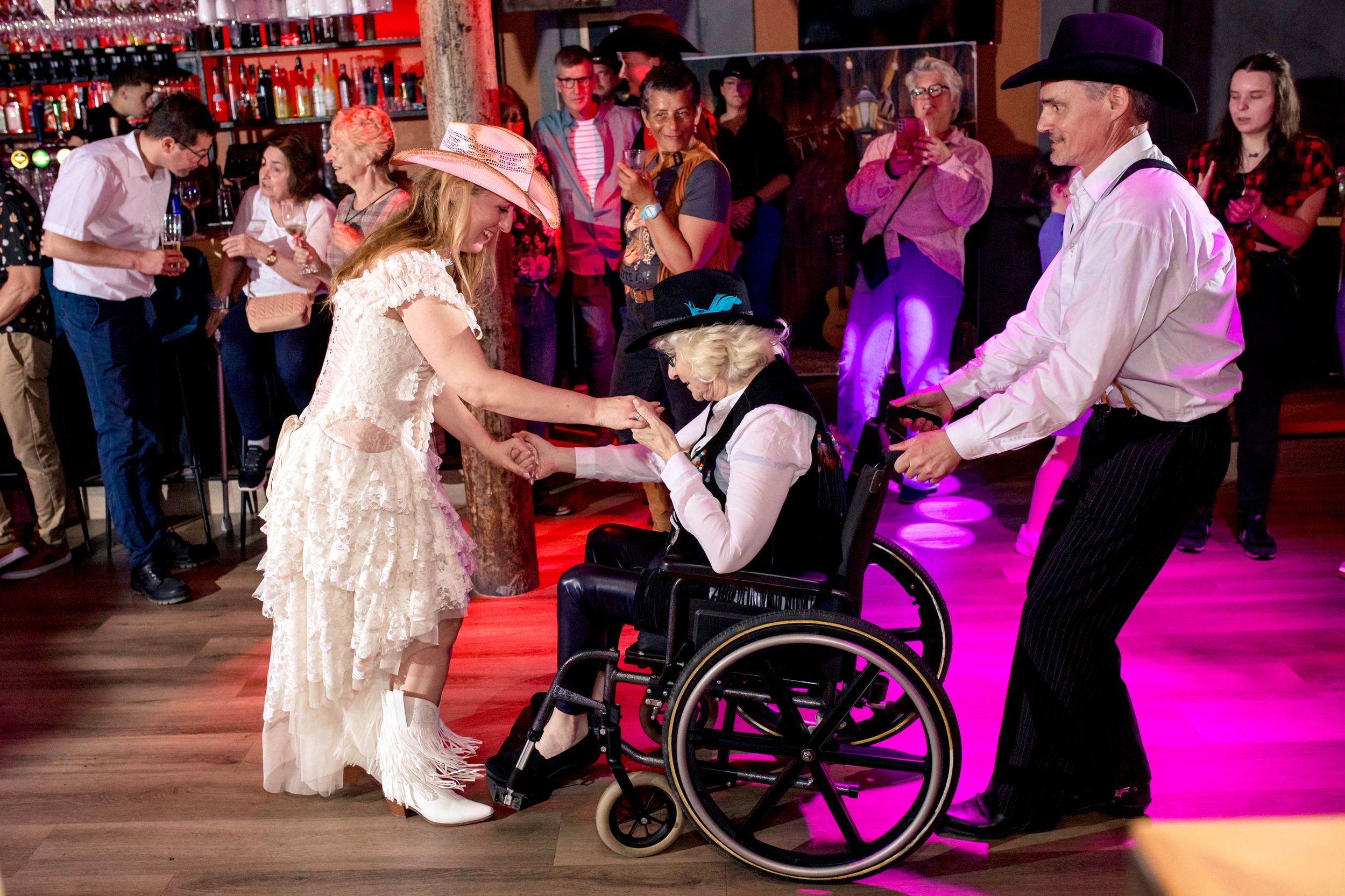 Emotioneel moment waarbij de bruid met haar moeder in een rolstoel samen dansen bij Batavia in Wormer
