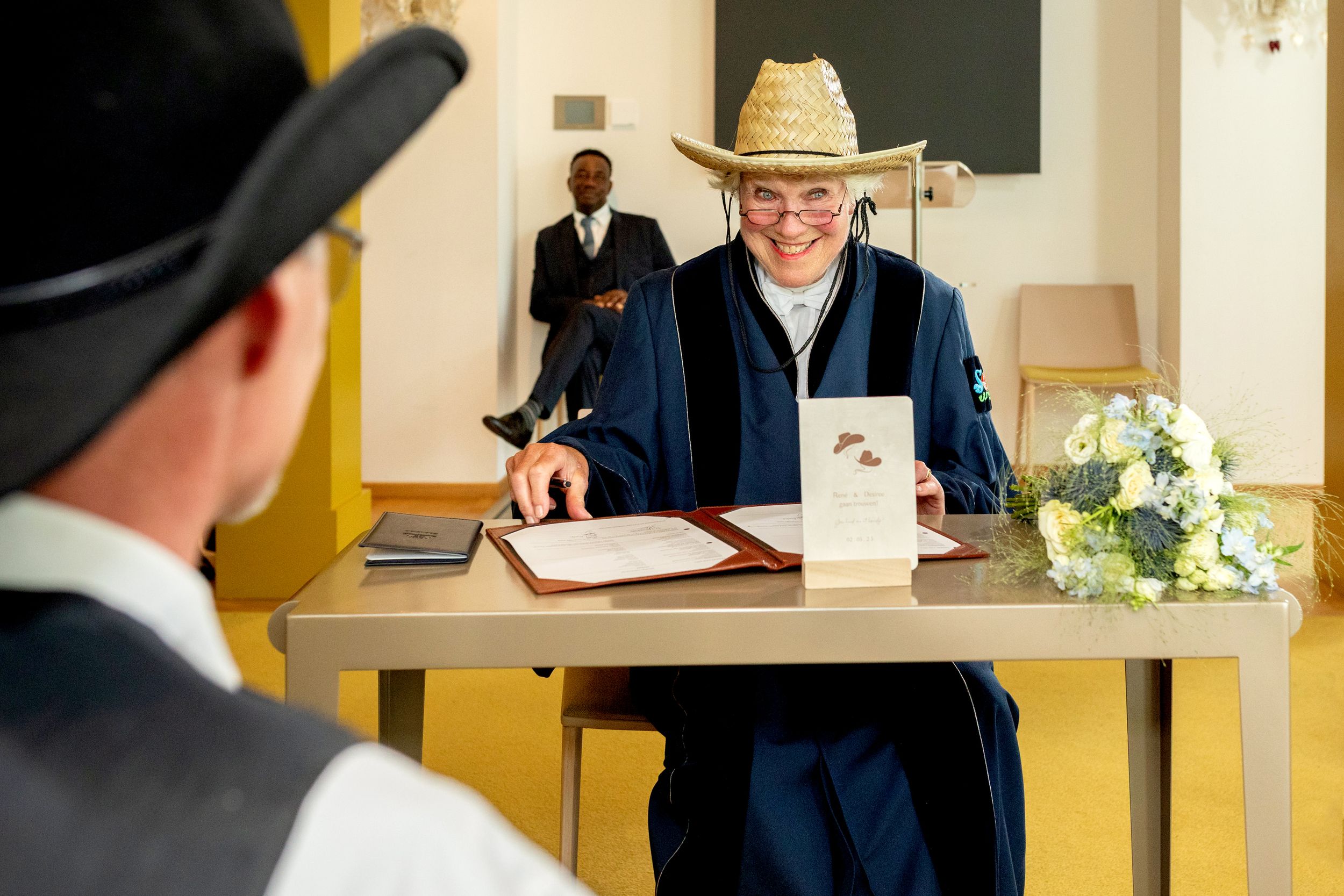 Ambtenaar van de burgerlijke stand in cowboystijl met hoed tijdens de ceremonie in het stadhuis van Zaandam