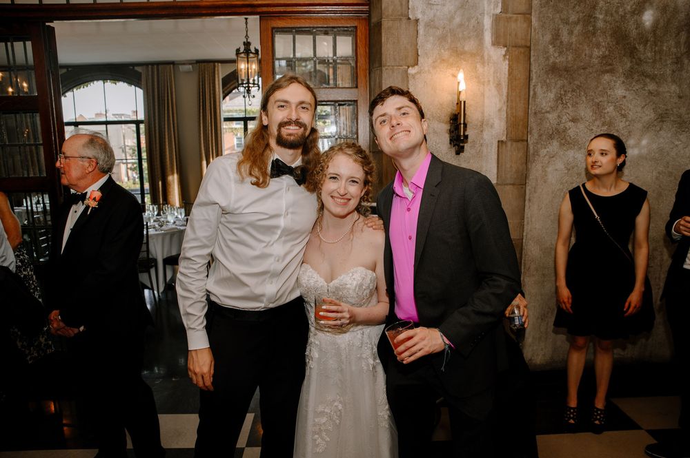 Wedding guests celebrate at a reception in a rustic venue with stone walls and candlelight.