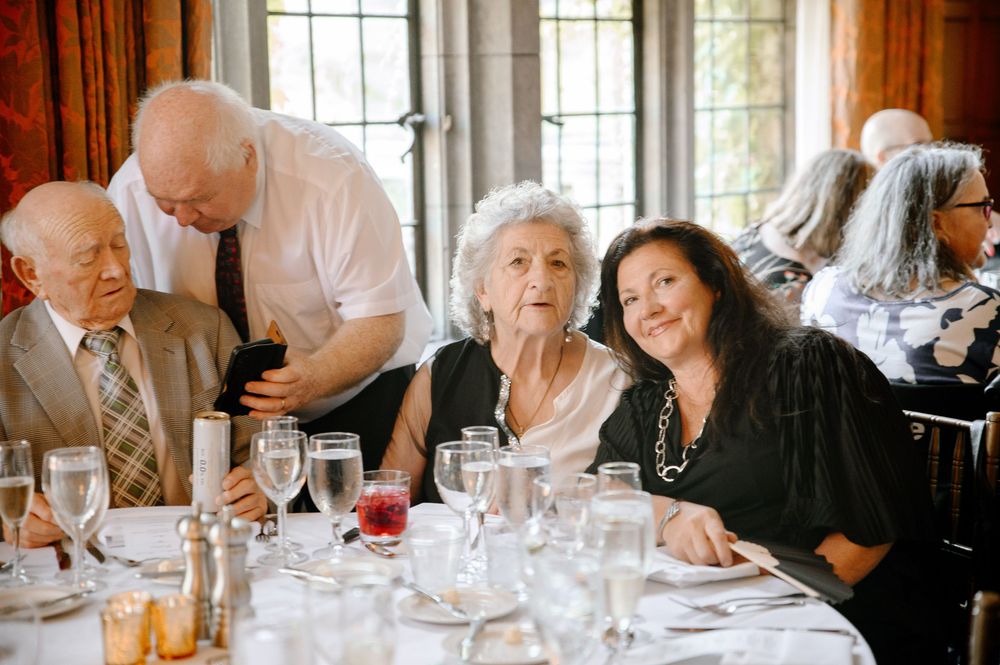 Group enjoying conversation at an elegant wedding reception dinner table.