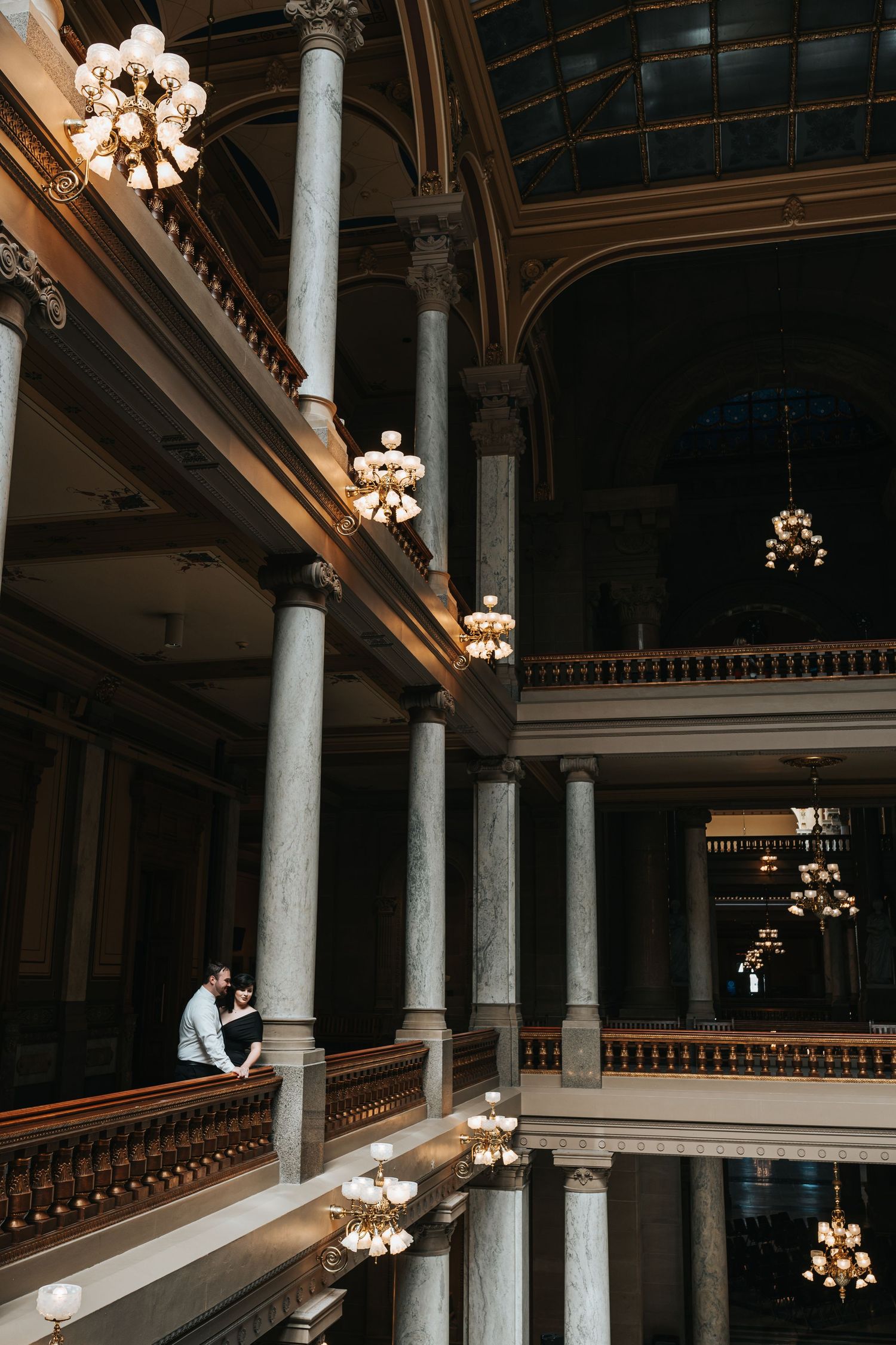 Elegant interior of historic building with columns and crystal chandeliers captured in dramatic lighting.