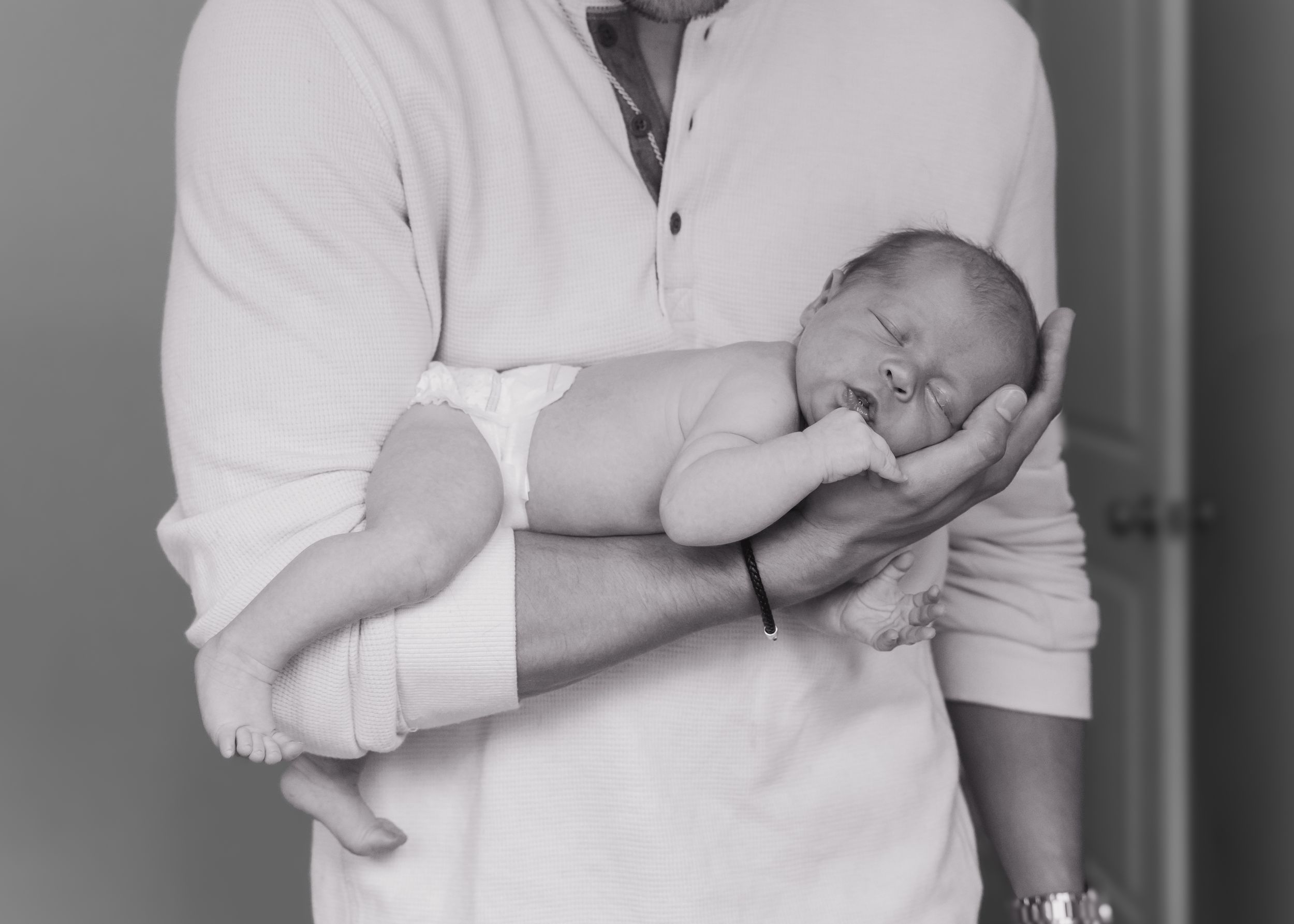 Series showing gentle moments with a newborn baby in white clothing.