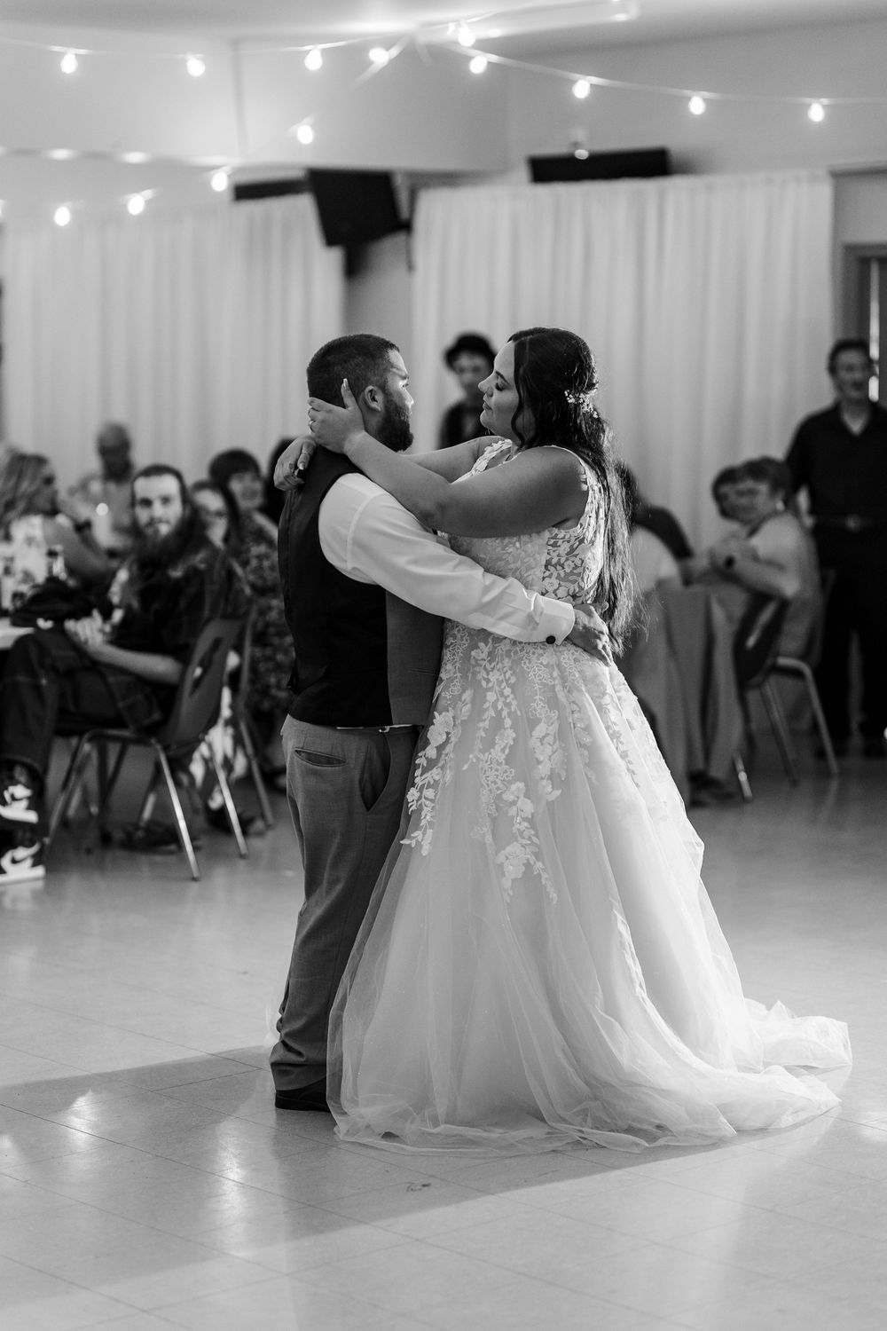 Black and white sequence of a couple's first dance at their wedding reception showing graceful dips and spins.