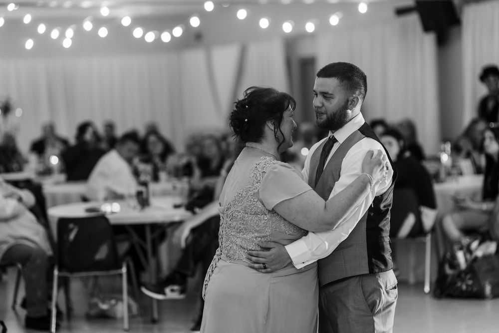 A black and white photo of a couple sharing an intimate dance at their wedding reception.
