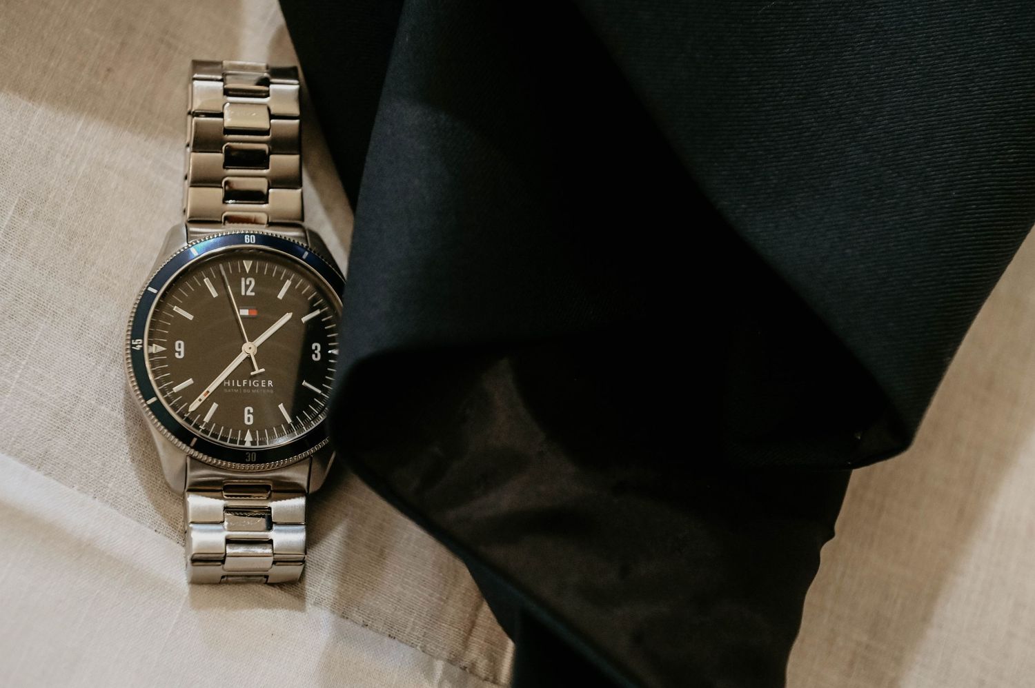 Silver stainless steel watch bracelet links and clasp mechanism shown in detail on dark background.