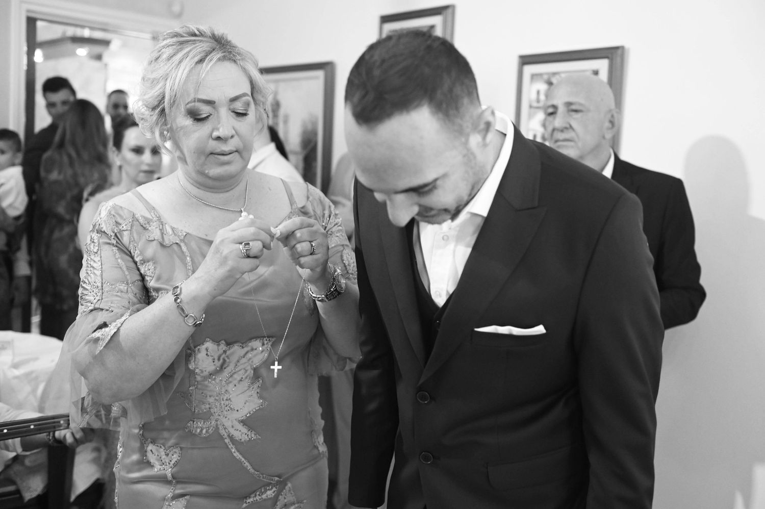A couple shares an intimate moment in black and white as they stand closely together at an indoor event.