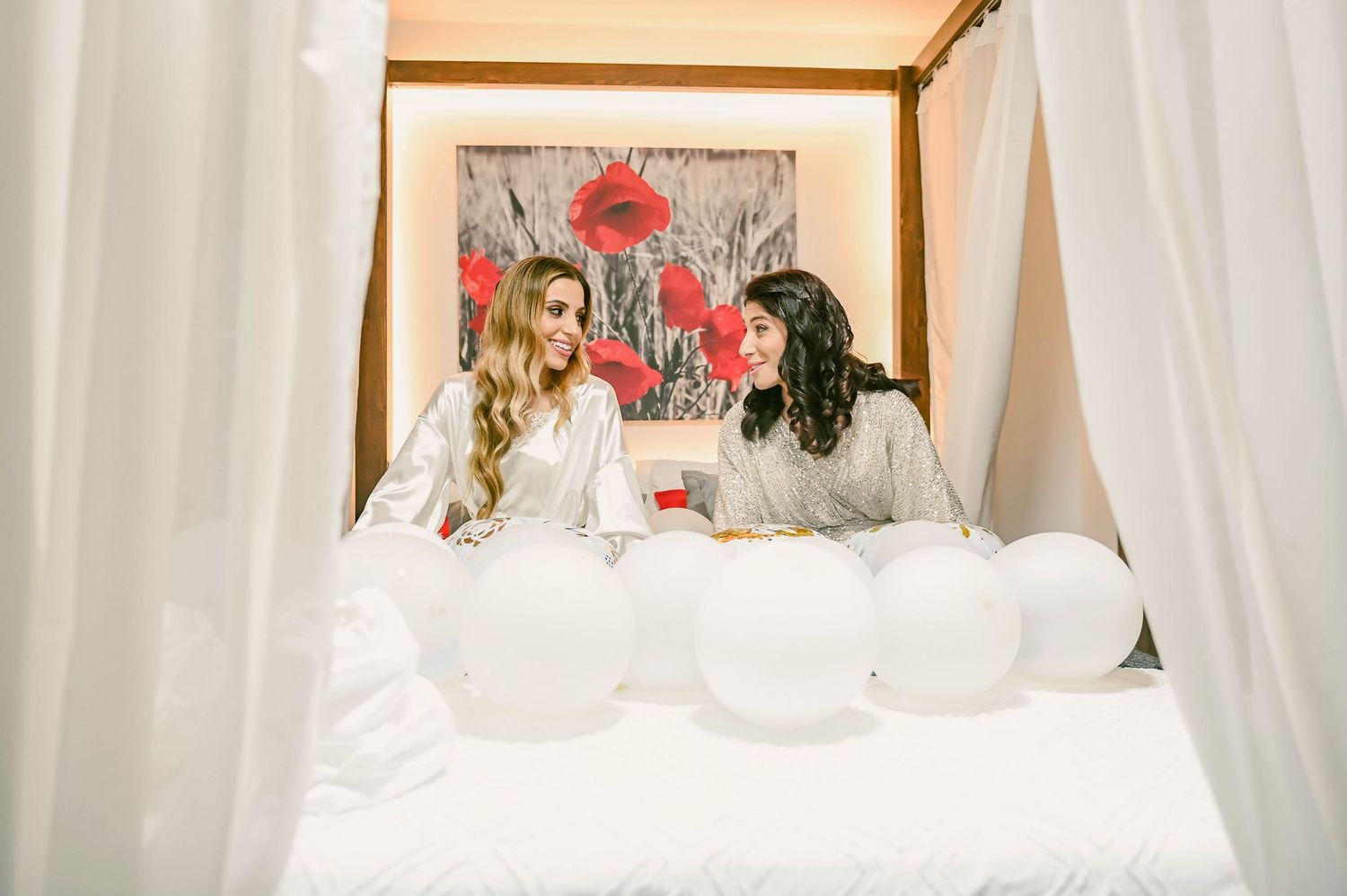 White tent-like fabric draped from ceiling to floor creates an ethereal wedding ceremony backdrop and aisle.