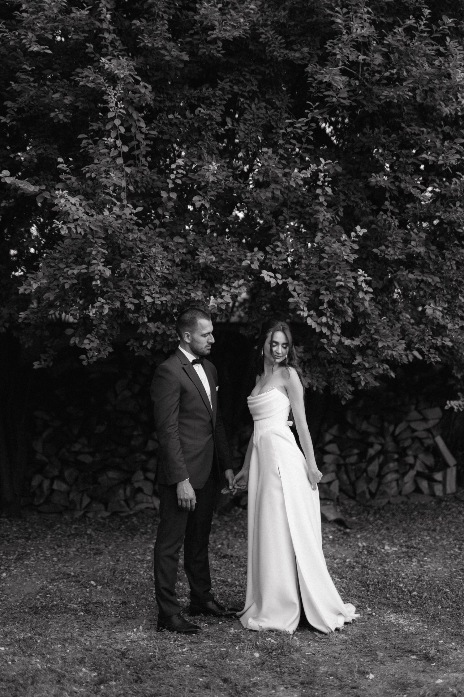 A black and white wedding photo sequence shows a couple sharing candid moments together in a wooded setting.