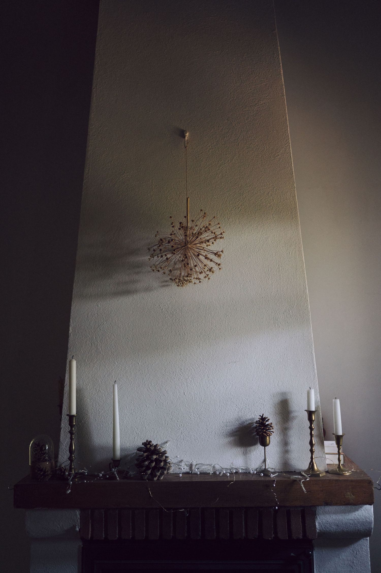 A series of six moody photographs showing candlesticks and decorative items on a wooden mantel in dim lighting.