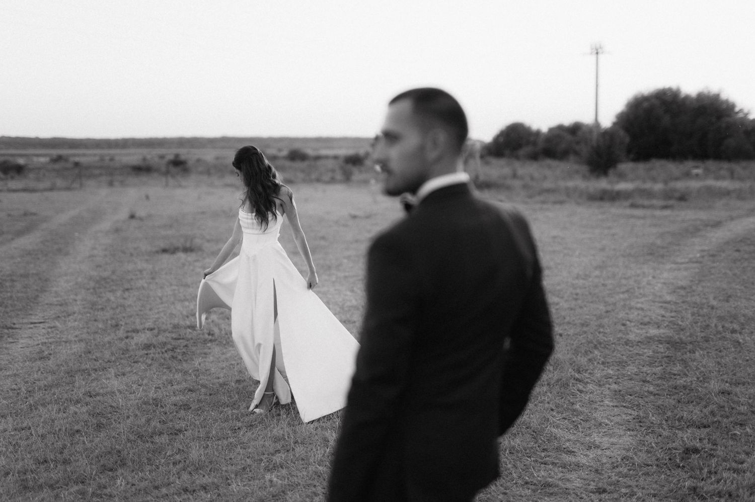 A series of black and white photos showing silhouettes of a person and a dress or fabric blowing in the wind.
