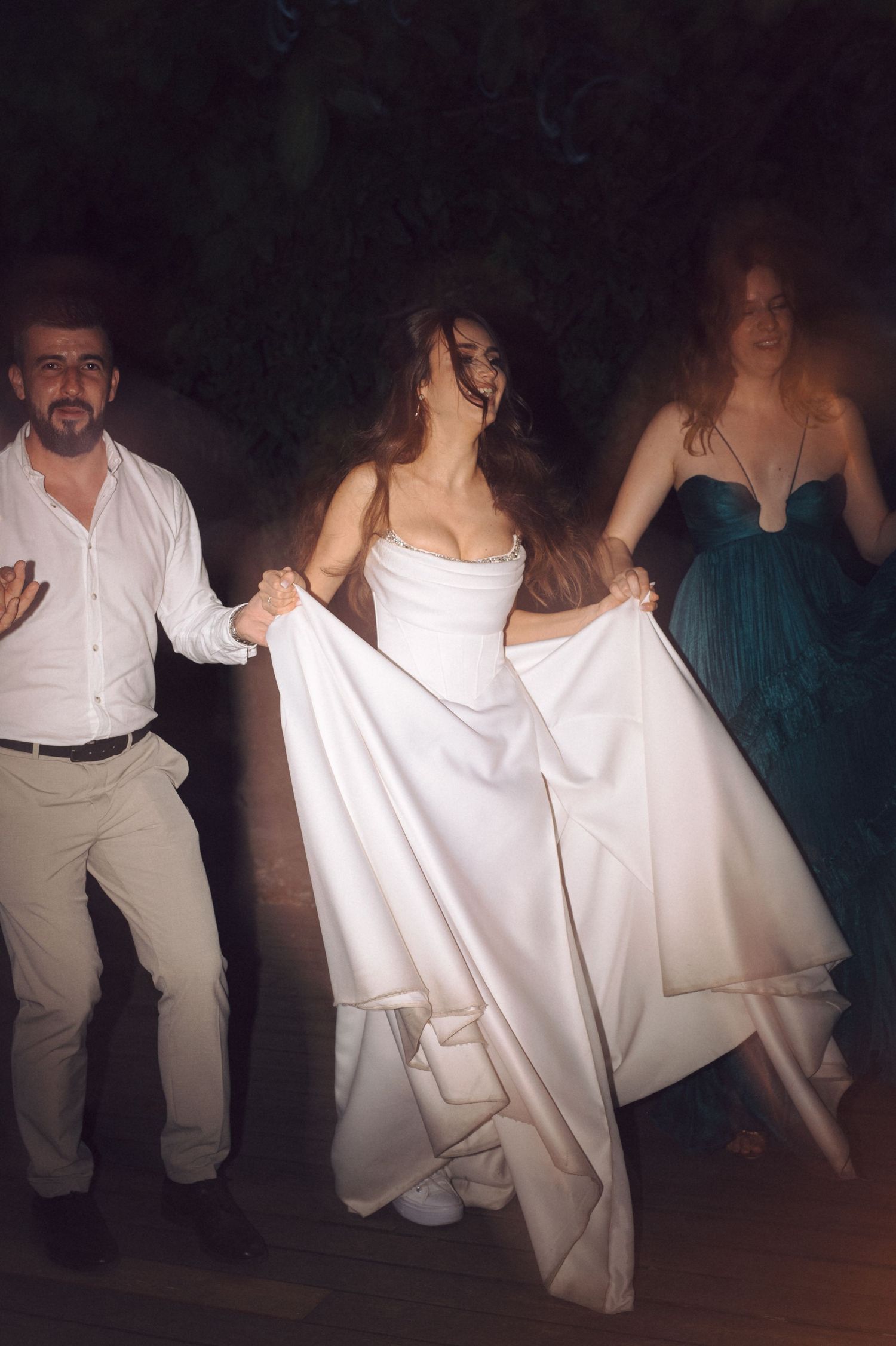 People in white and dark clothing dancing on a dimly lit dance floor, creating a series of dynamic motion shots.