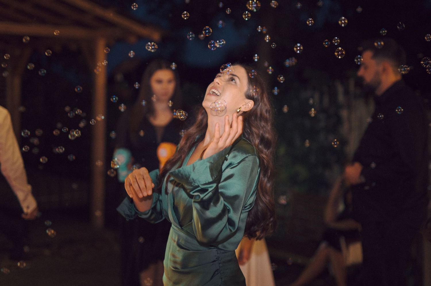 Two people dancing salsa in a dimly lit setting with colorful lights sparkling in the background.