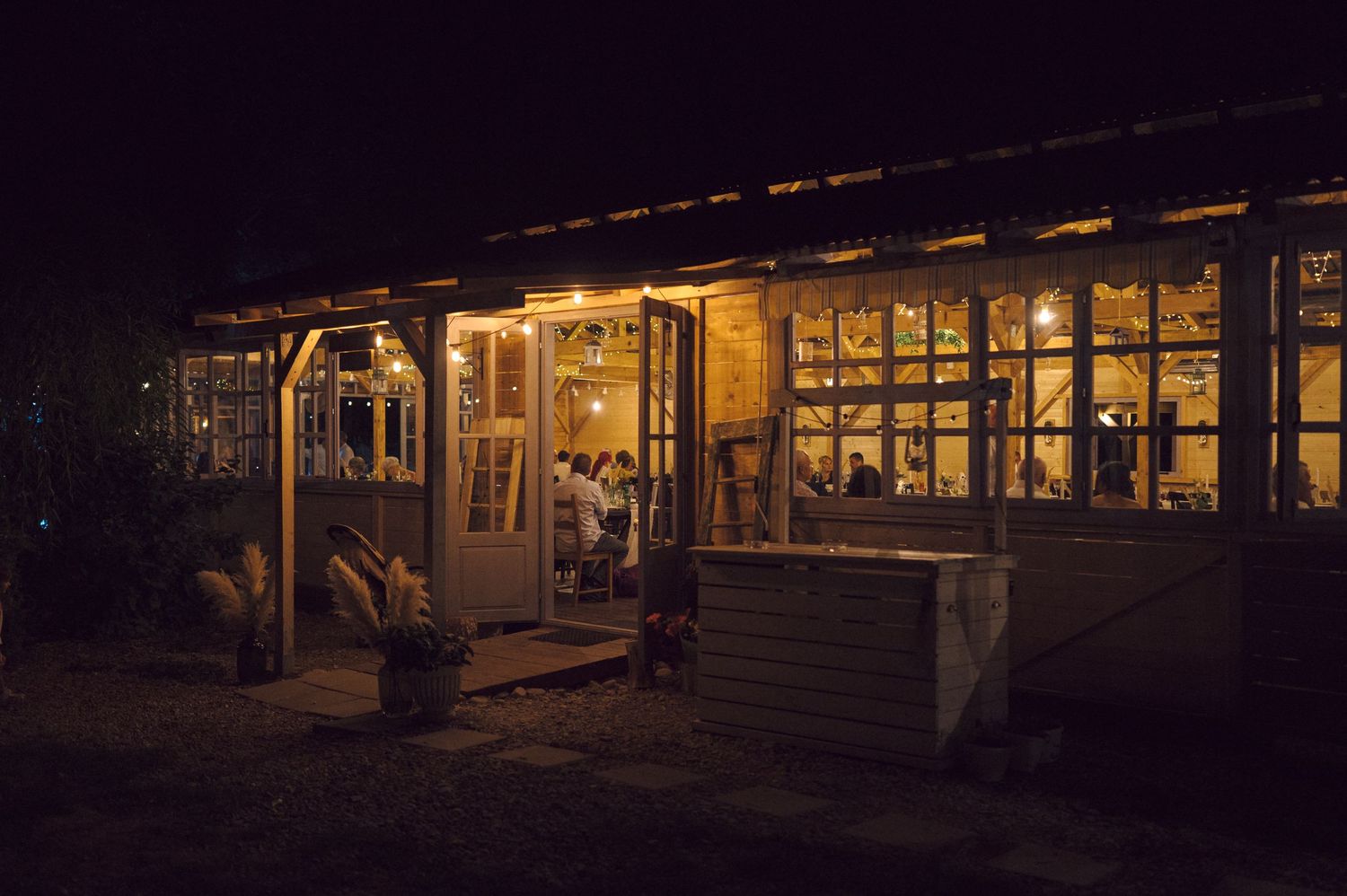 Illuminated storefront windows glow warmly at night, reflecting onto a dark commercial street.