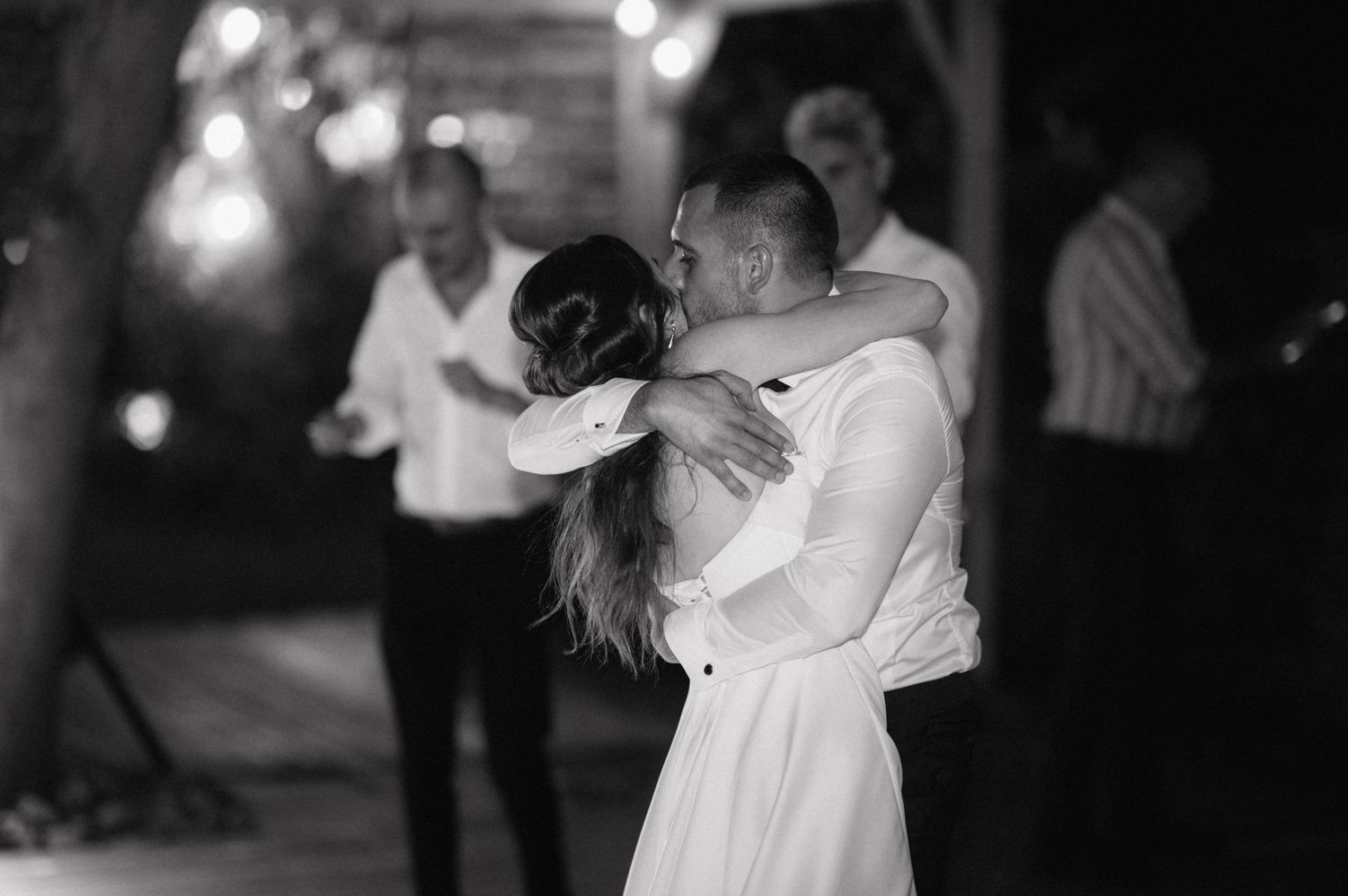 A collection of black and white candid wedding photos showing couples dancing at a romantic reception.