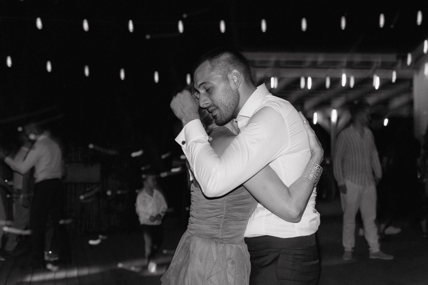 Black and white film strip showing multiple dance scenes with couples dancing closely together at what appears to be a social event.