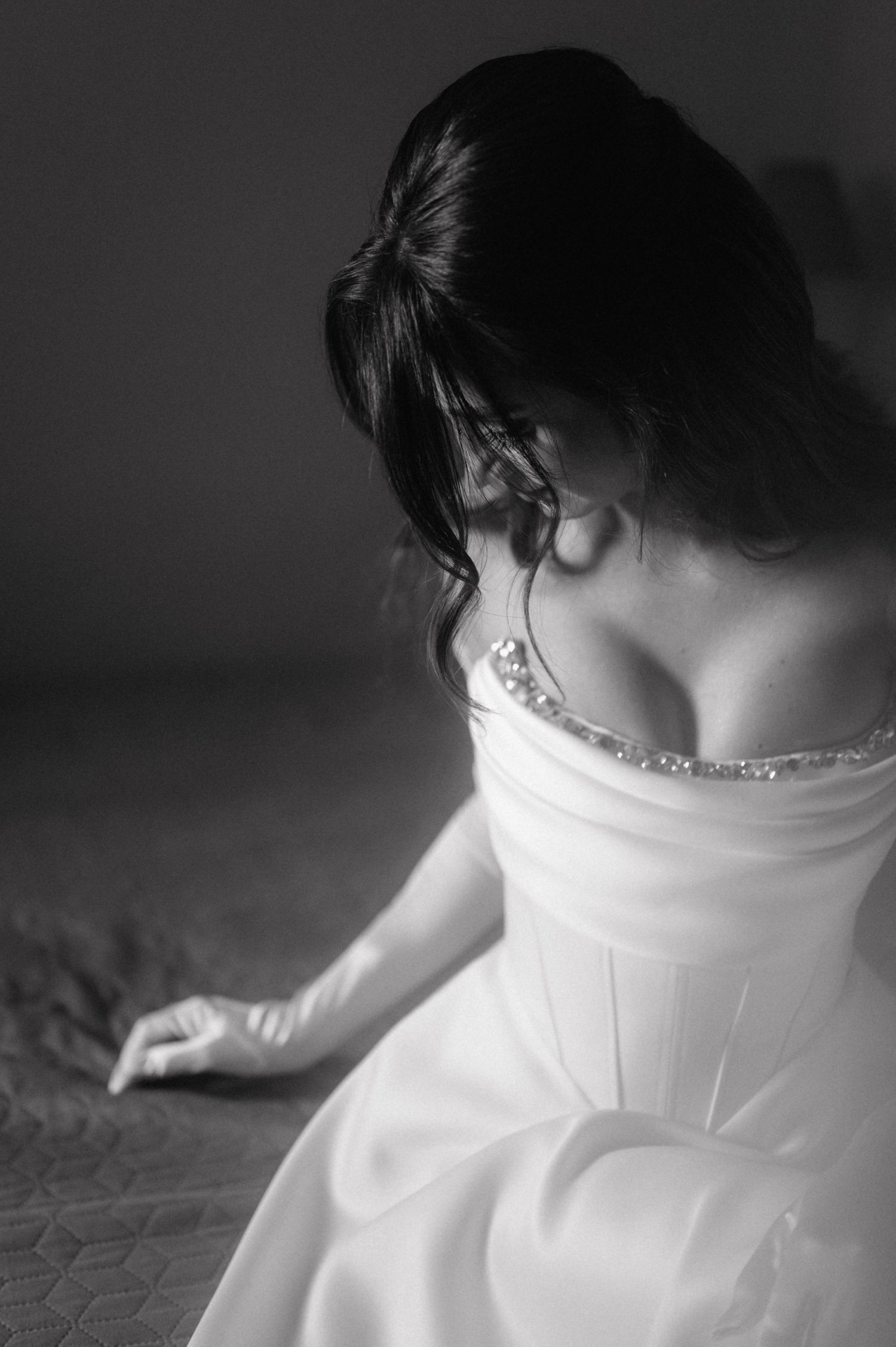 A black and white sequence of images showing details of a white wedding dress with intricate stitching and beadwork.