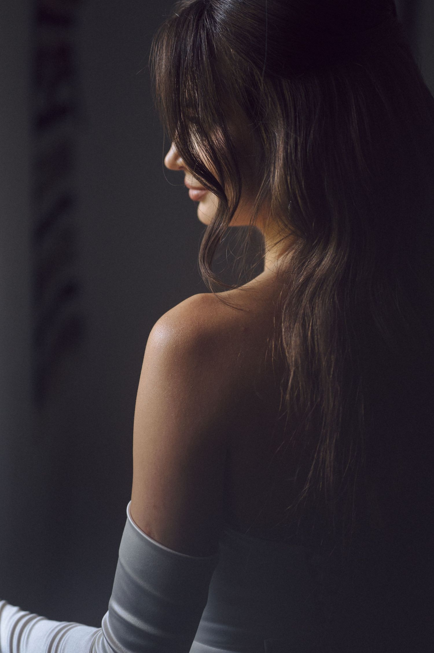 A series of moody profile portraits showing flowing dark hair against a shadowy background.