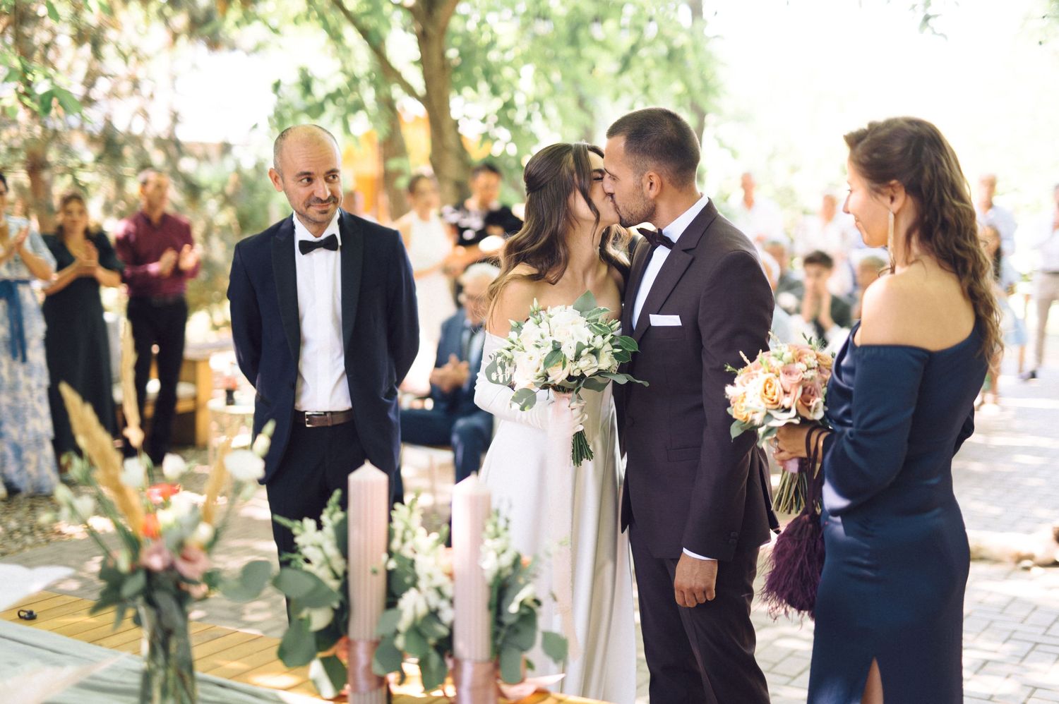 Wedding guests mingle and converse during an elegant outdoor garden reception.